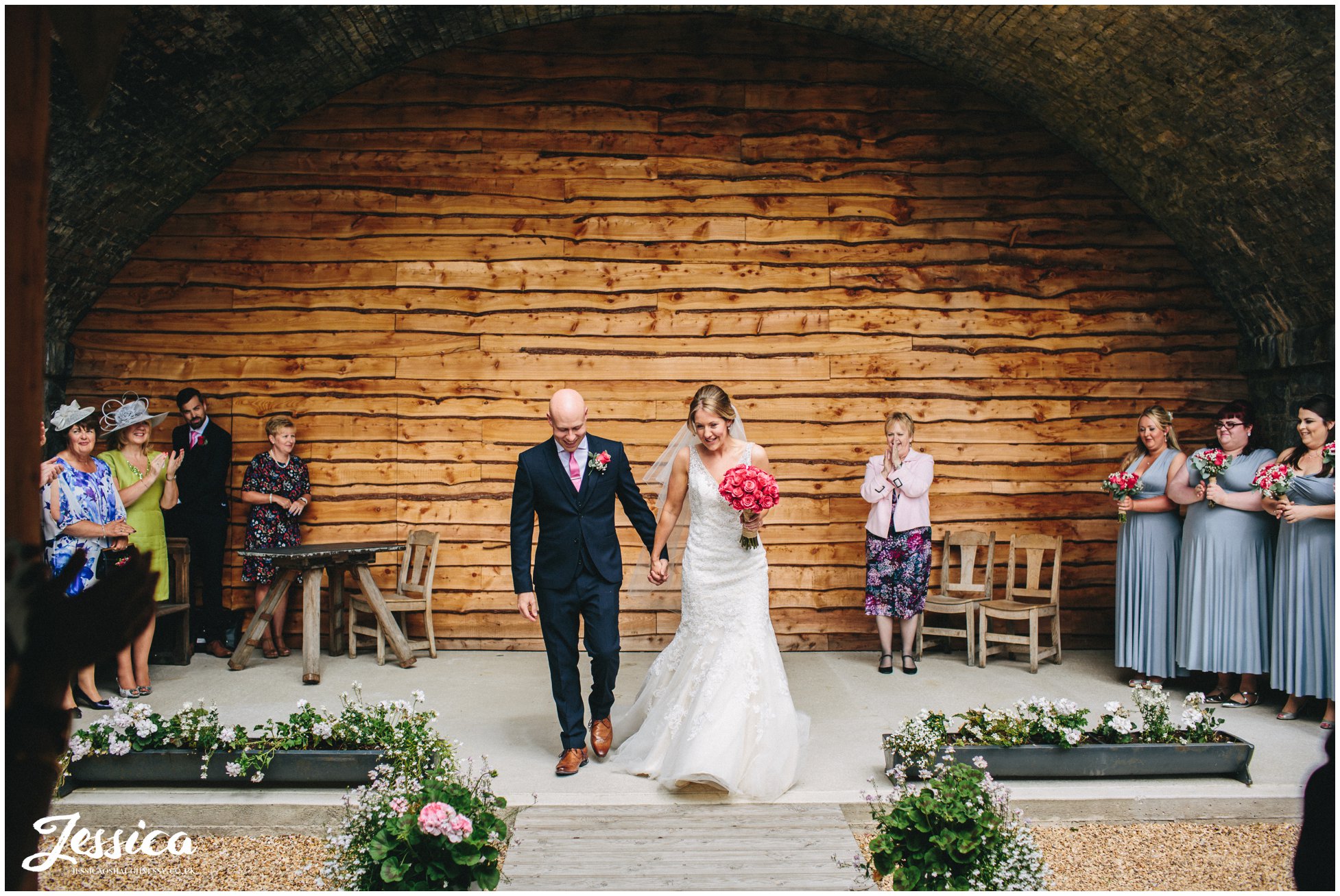 bride and groom under the bridge at tower hill barns after being announced husband and wife