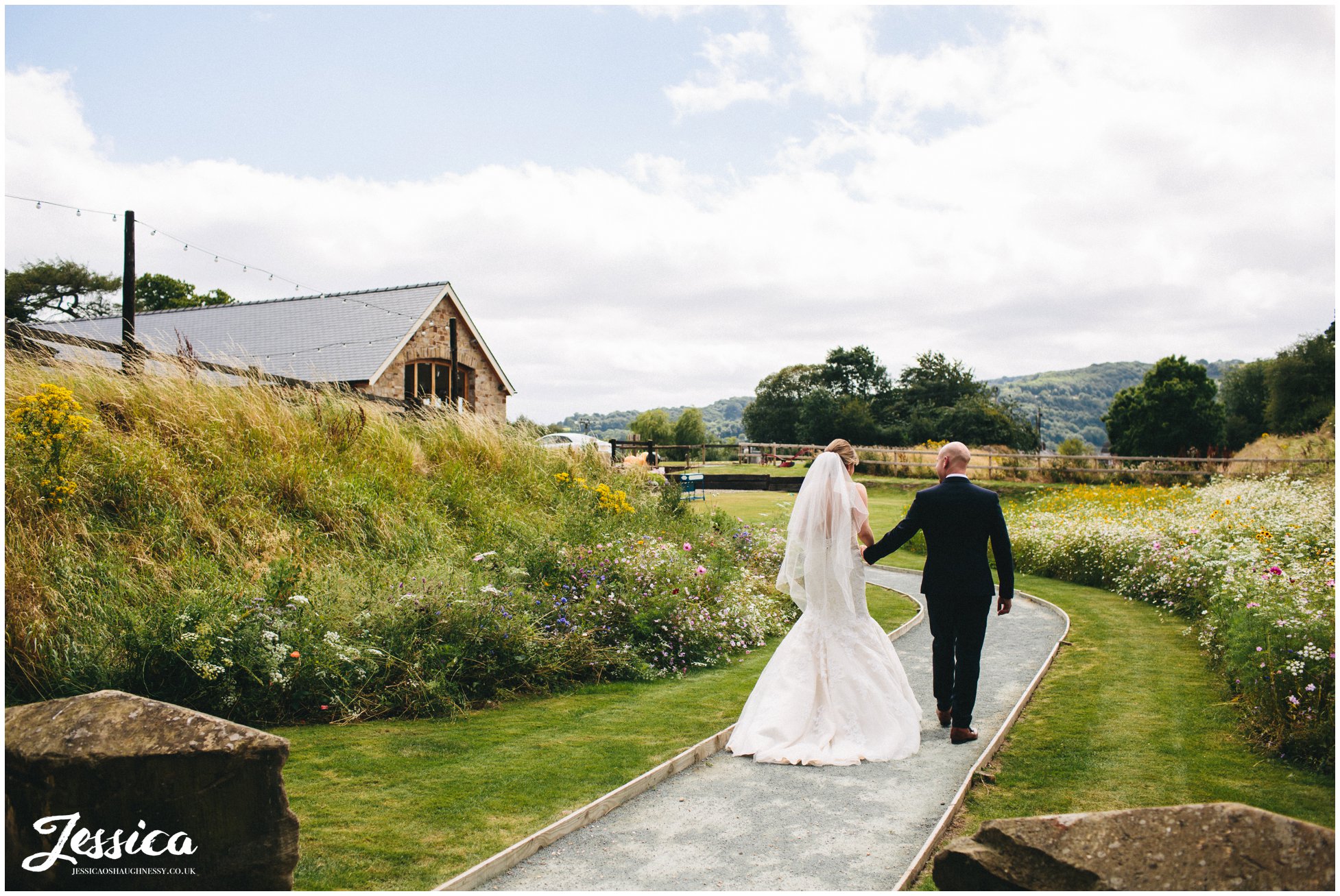 newly wed's walk down path after their wedding ceremony in north wales