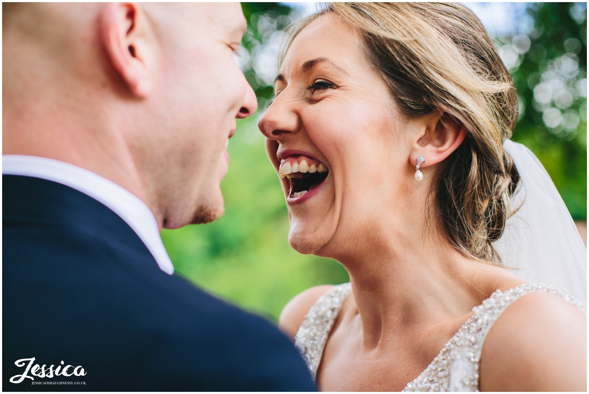 close up of bride and groom laughing at each other on their wedding day in wrexham, north wales