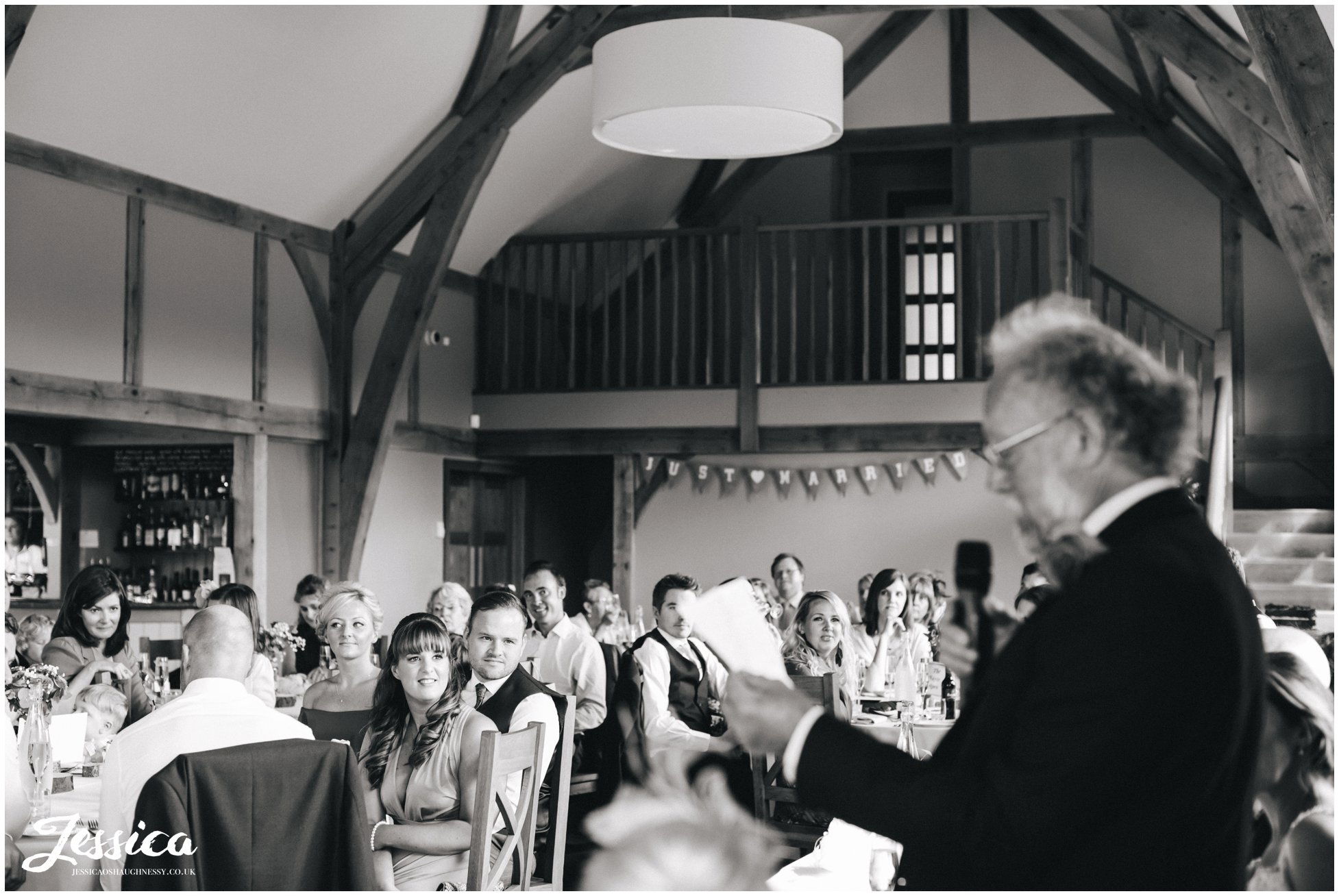 guests watching the father of the bride deliver his speech