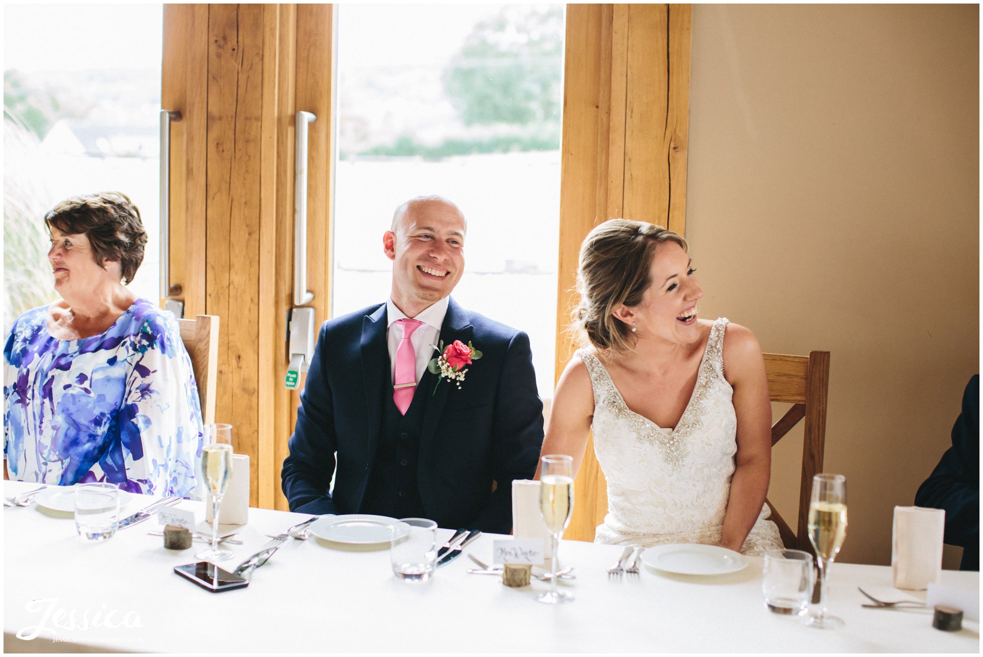 newly wed's laugh during their speeches at tower hill barns wedding venue