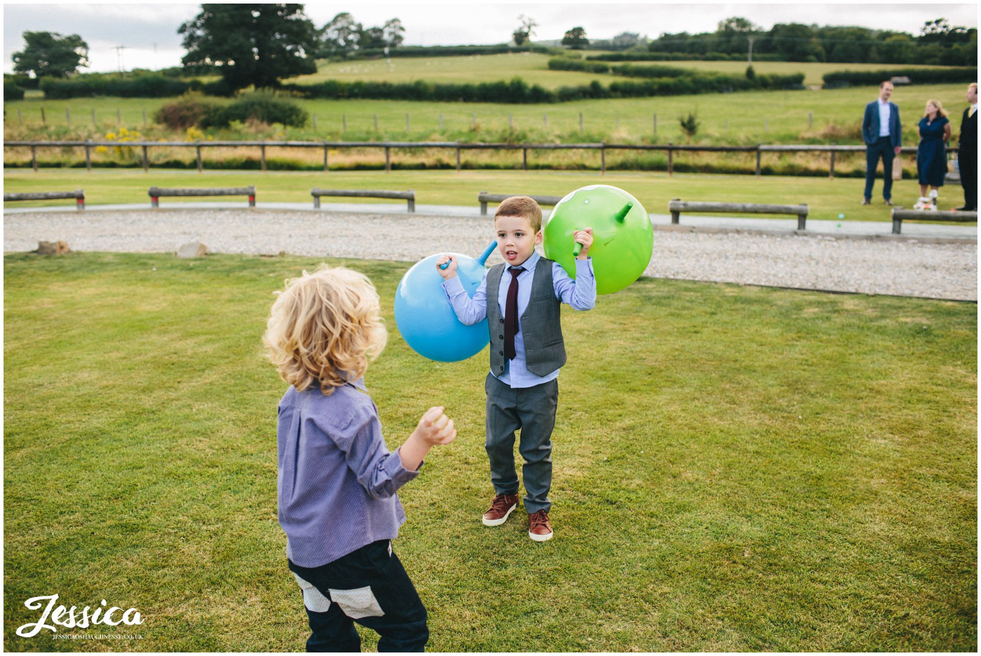 children playing with space hoppers on the grass at a north wales wedding
