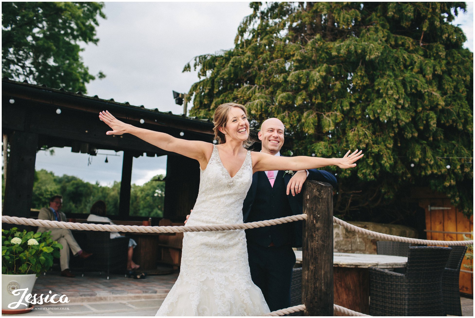 bride & groom laughing outside the smoking hut at tower hill barns