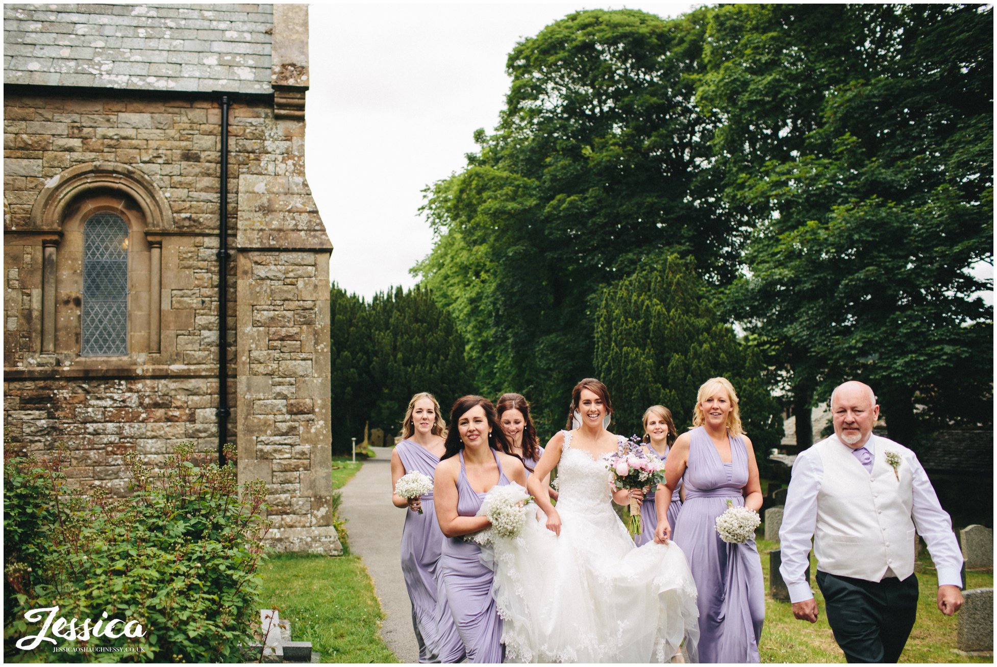 bride & bridesmaids walk up to St Bridget's Church in Bridekirk for the cumbria wedding