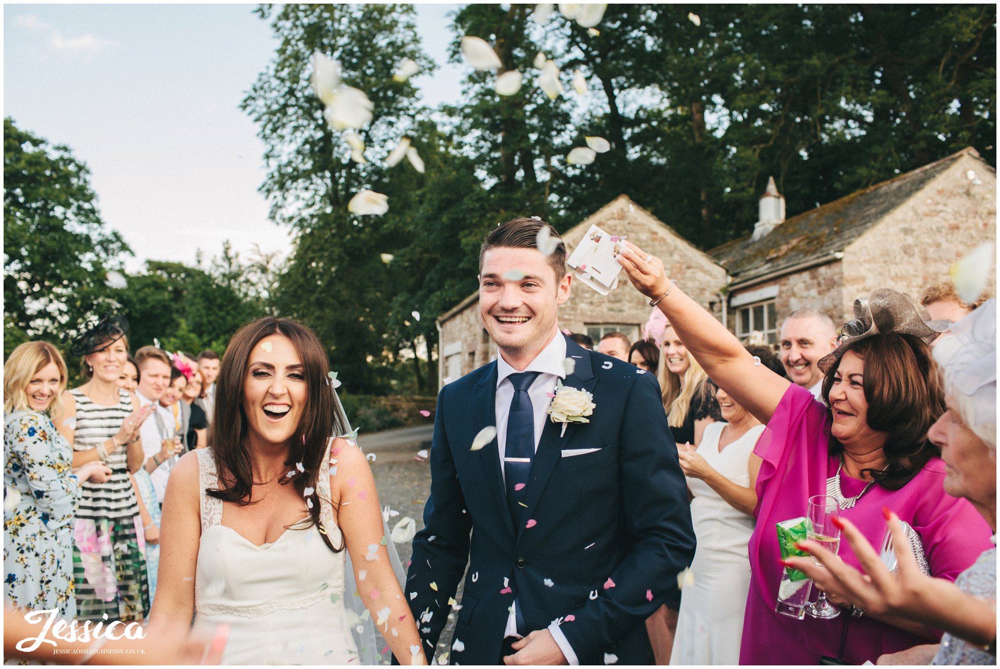 newly wed's walk through confetti line at their lake district wedding