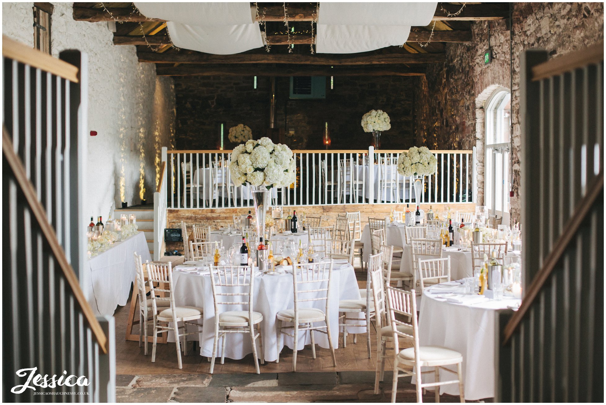 bank barn at askham hall decorated in ivory flowers ready for the wedding breakfast