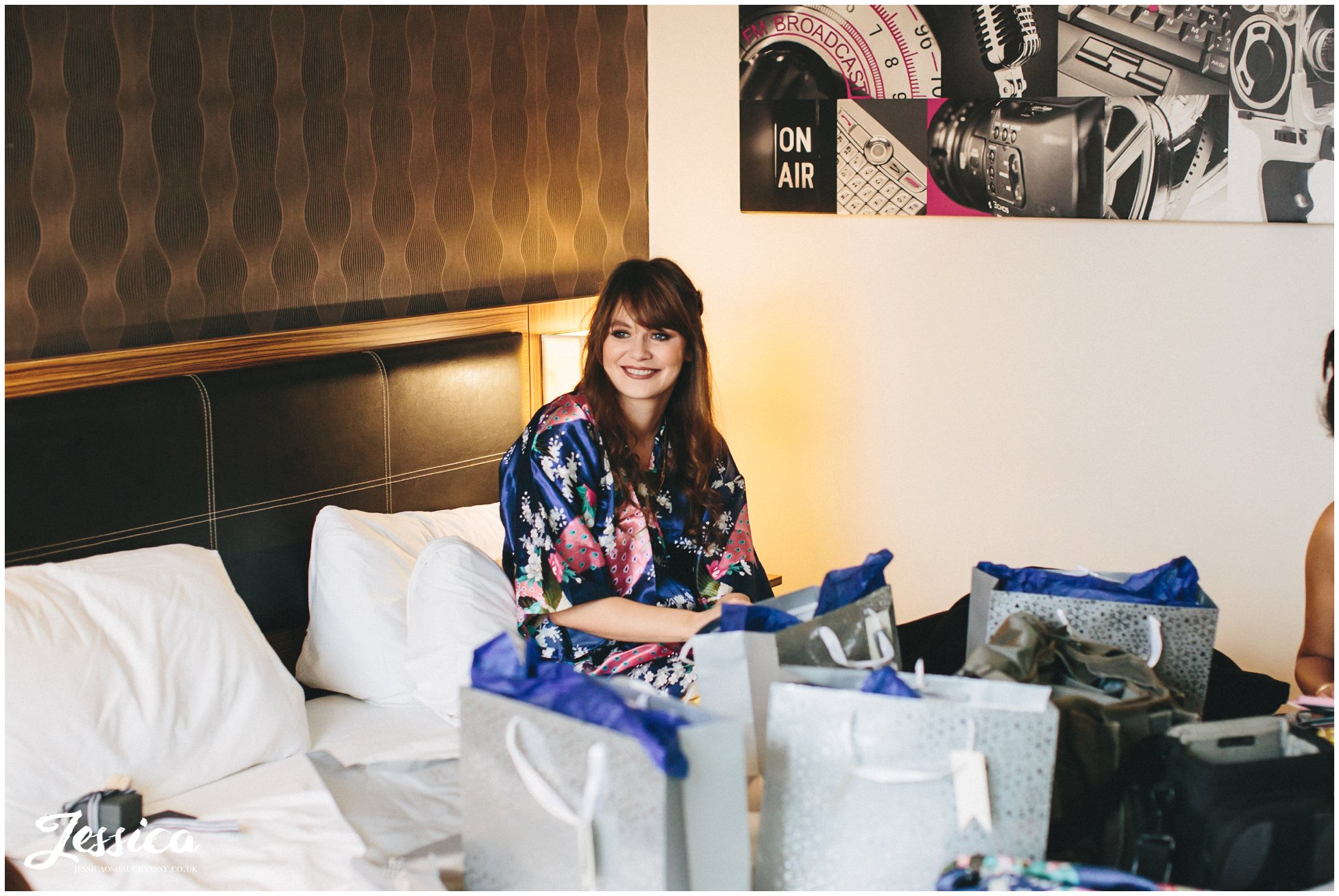 bridesmaid sits on bed laughing in holiday inn, media city