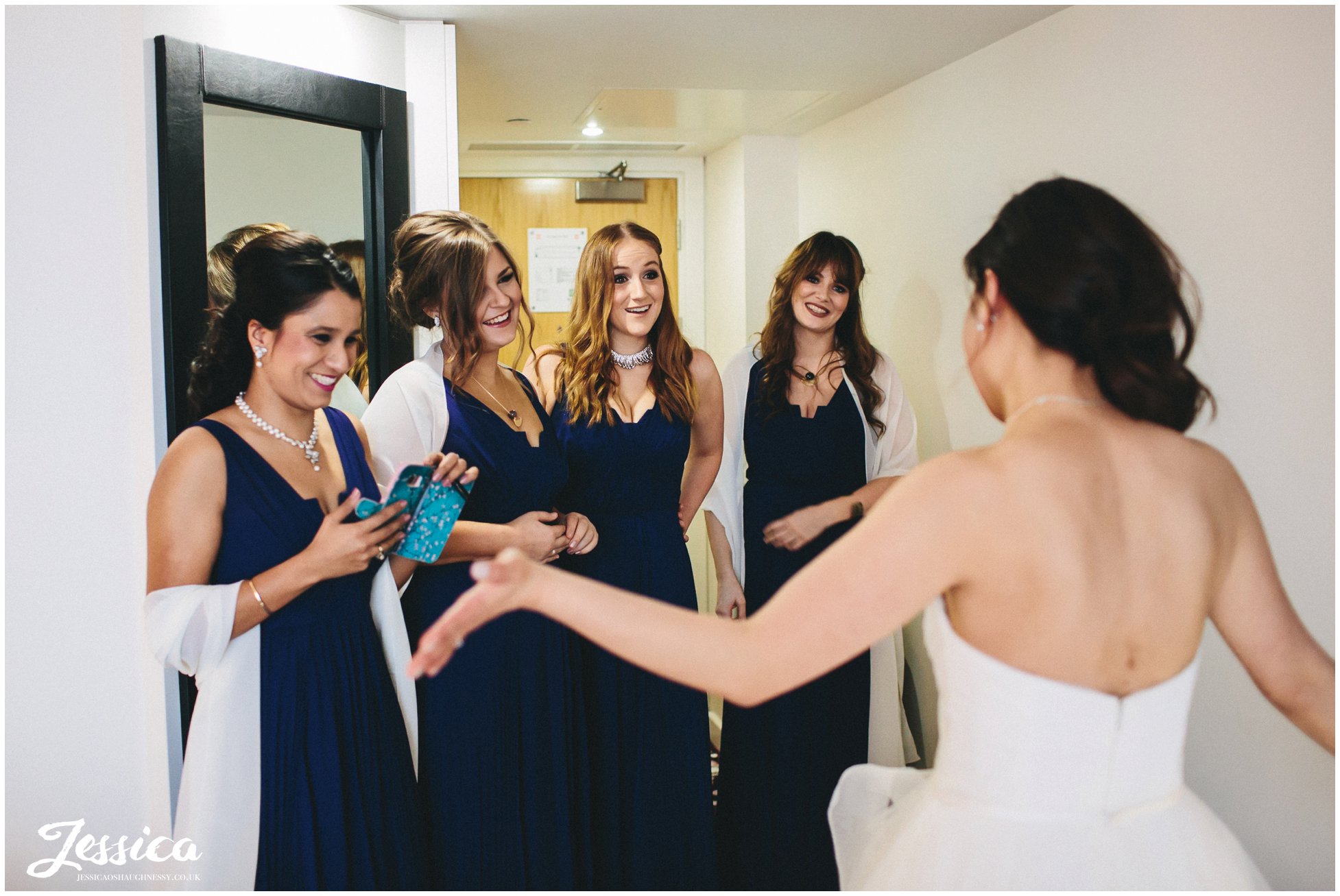 bridesmaids admire the bride & her dress before her wedding ceremony in manchester