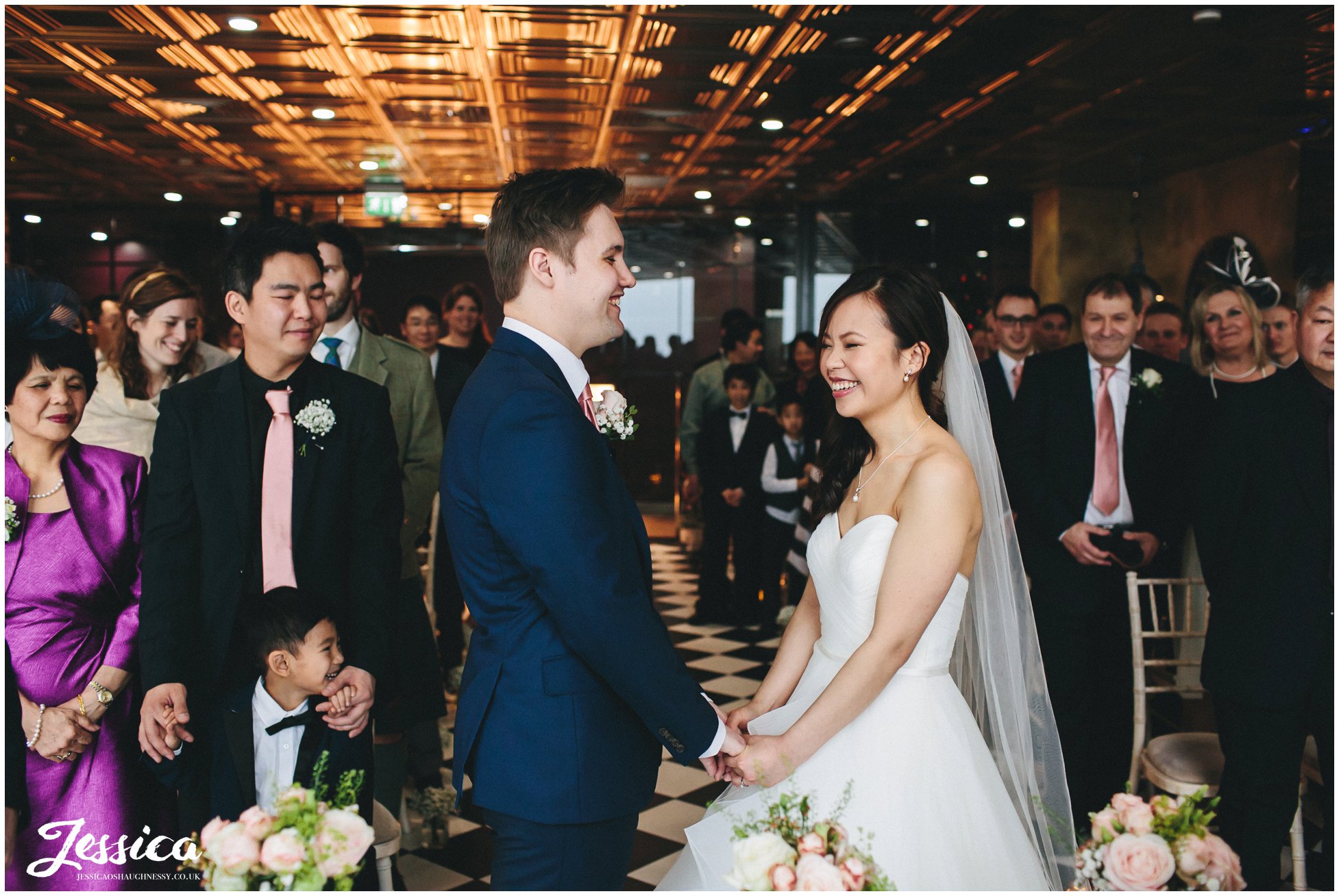 bride & groom hold hands during their ceremony at on the 7th - manchester wedding