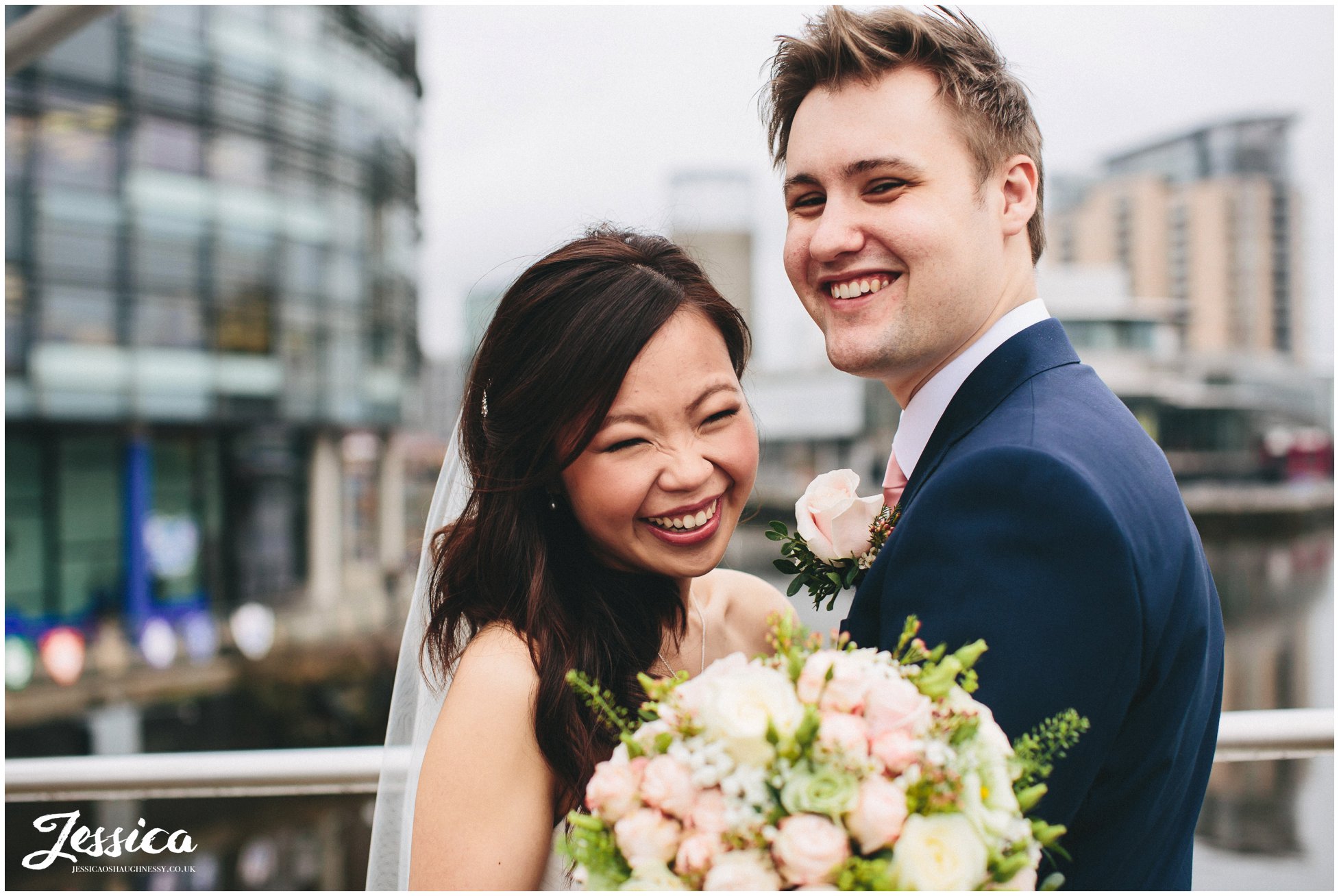 couple laugh on the media city bridge in salford