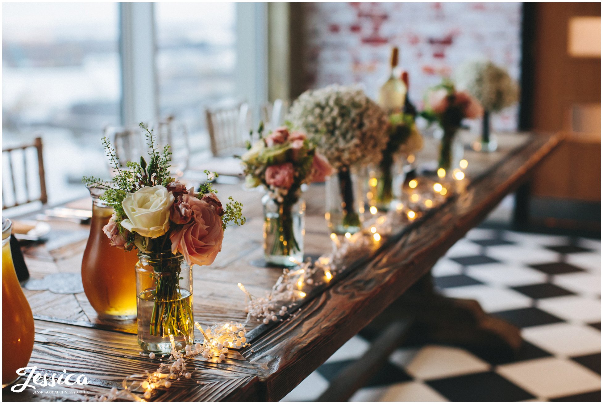 flowers in jars decorate the top table - On The 7th Wedding