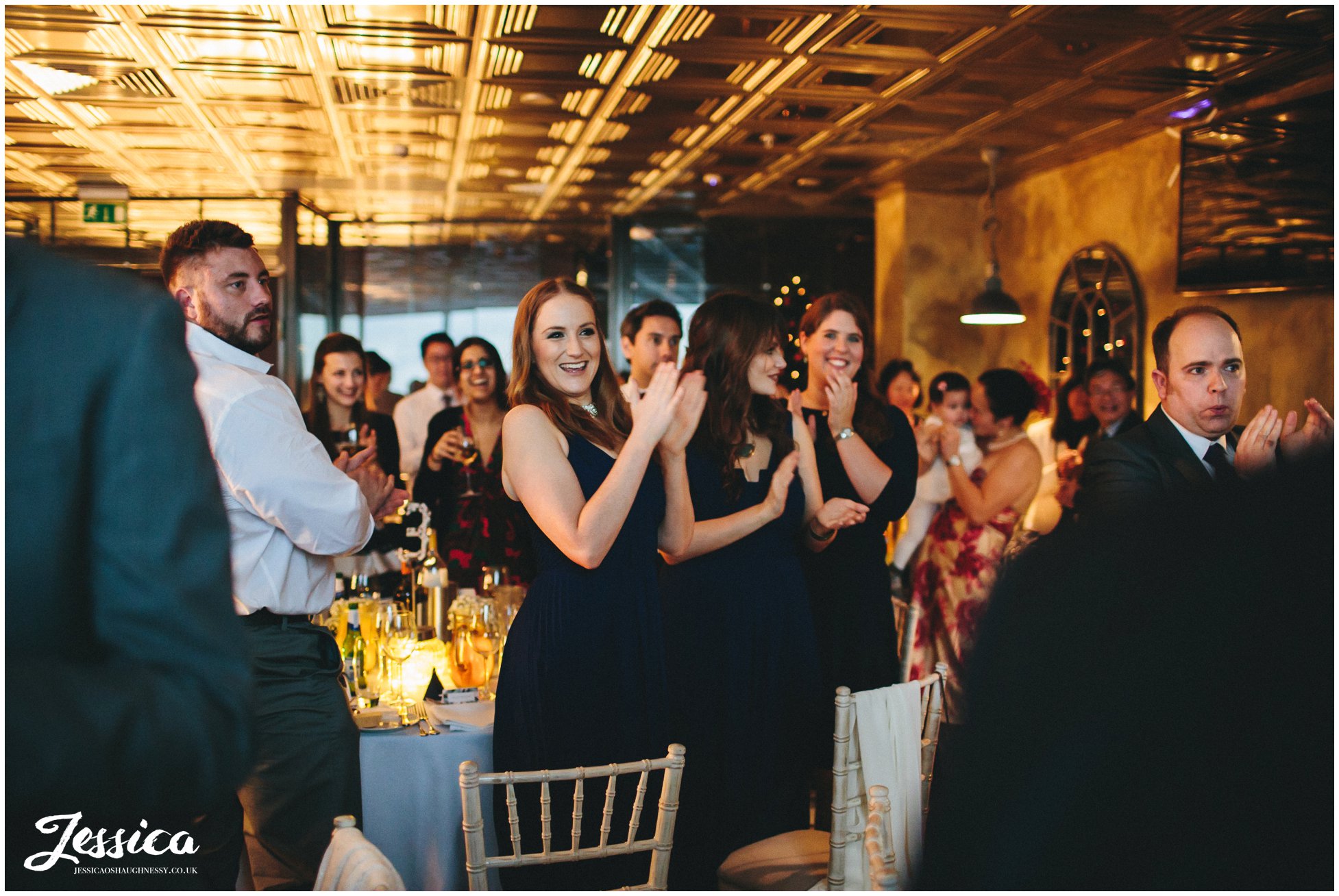 guests applaud newly wed's as they sit for their wedding breakfast in manchester