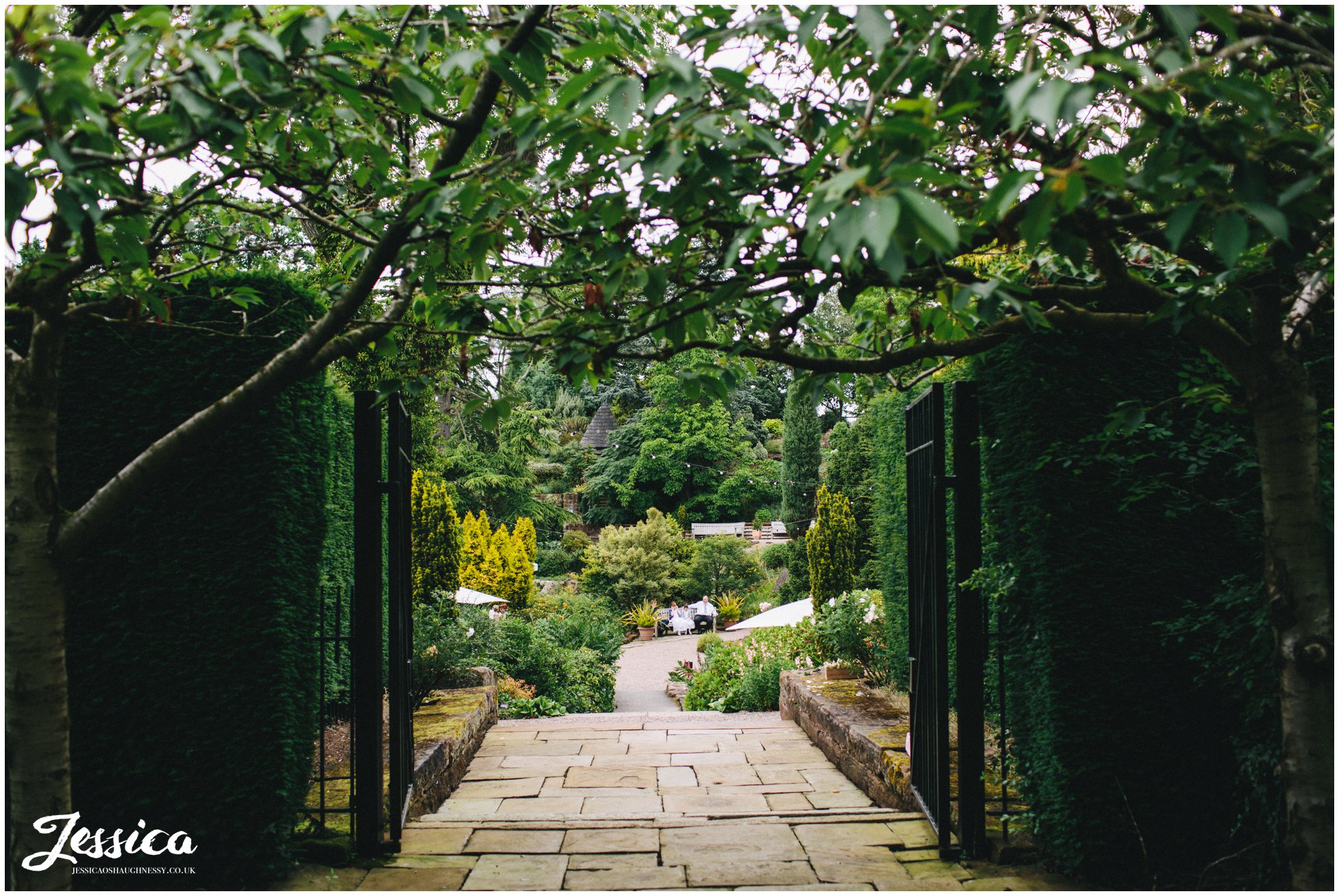 a view through the gates of ness gardens before the wedding