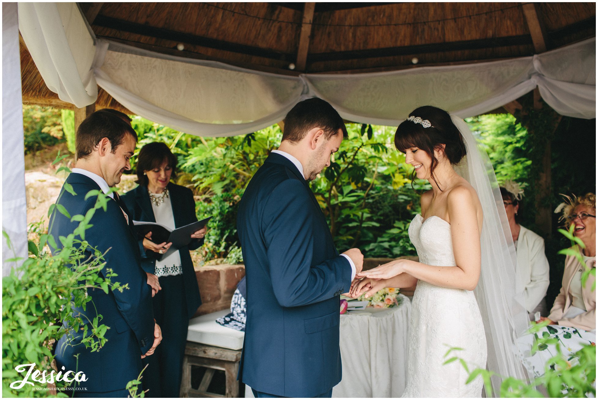 the bride & groom exchange rings at their ness gardens wedding on the wirral