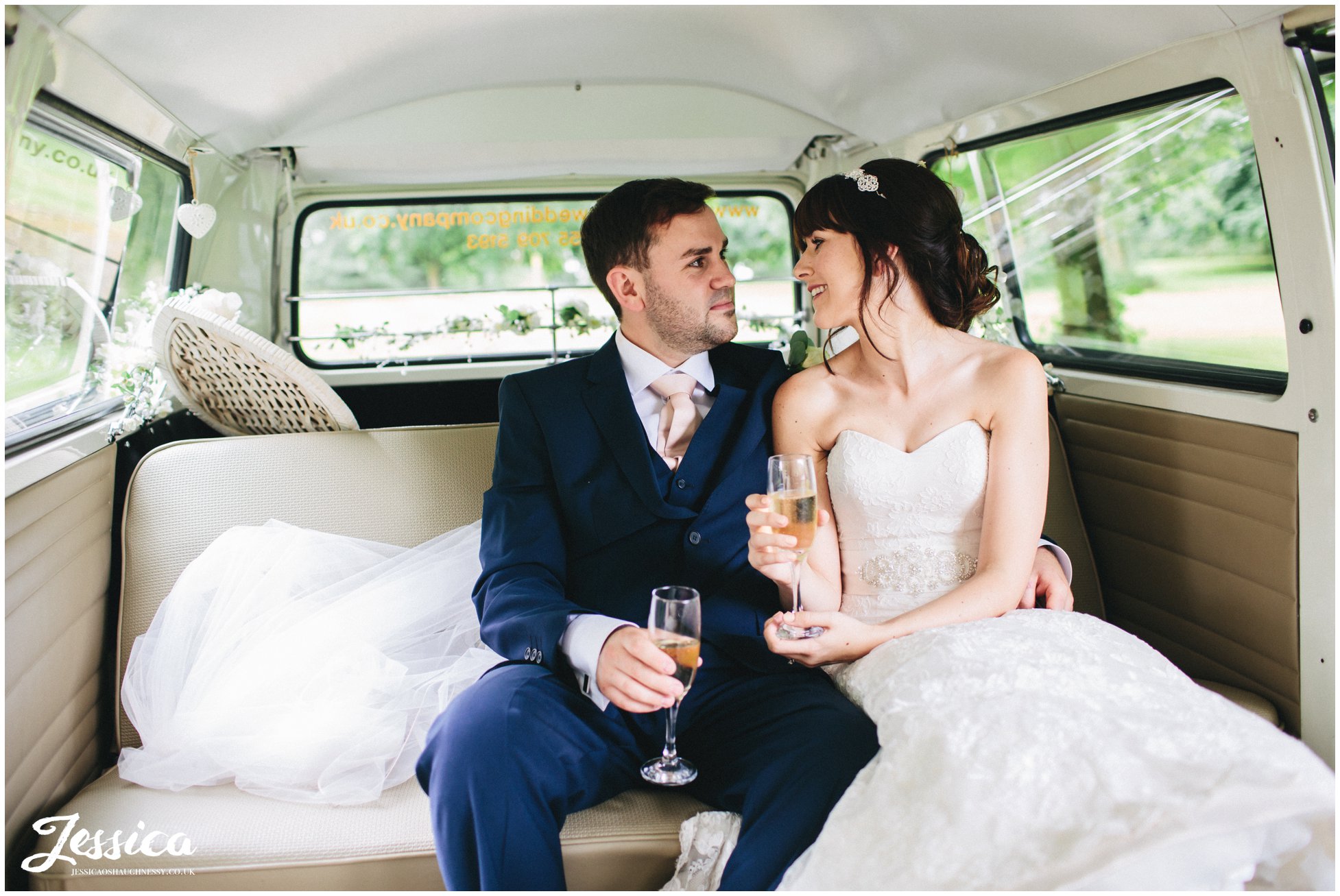 newly wed couple sip champagne in a VW camper at their ness gardens wedding