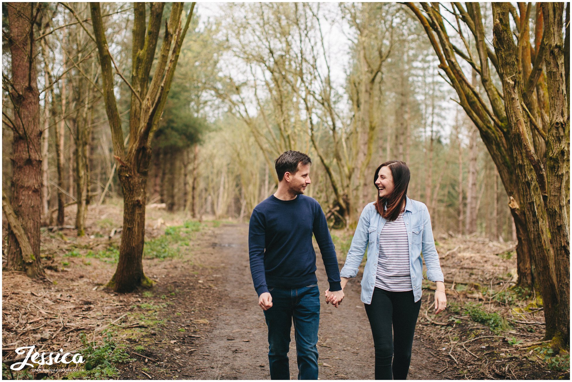 couple walk hand in hand through delamere forest - pre-wedding shoot