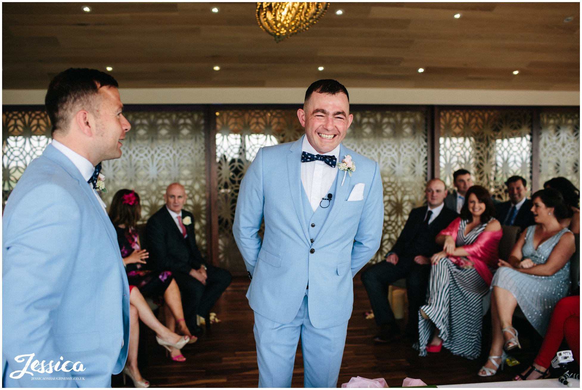 groom smiles as he waits for his bride to walk down the aisle at their sheldrakes wedding