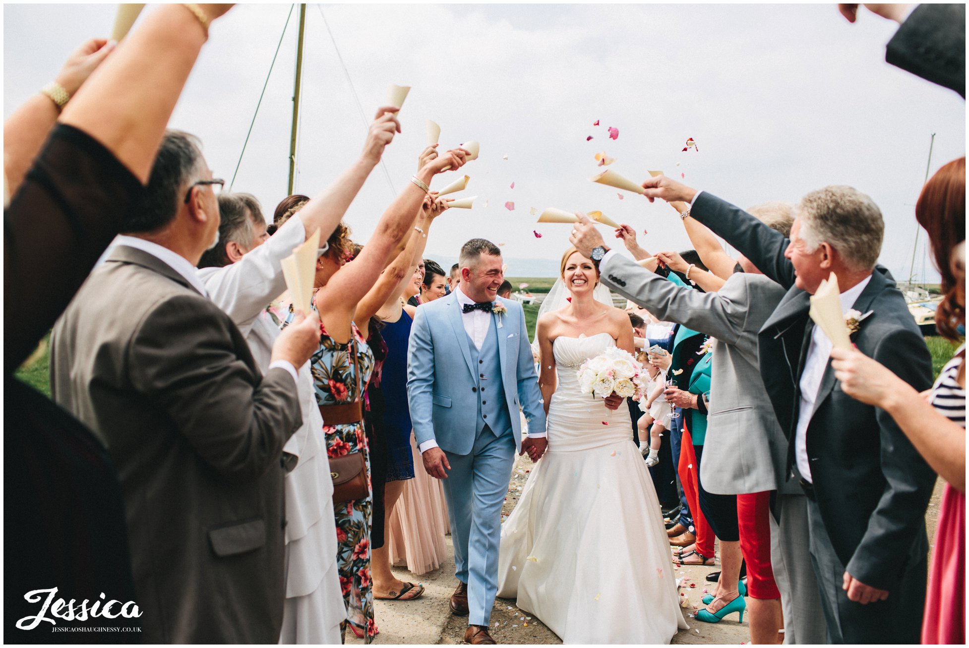 couple walk through the confetti line at their wirral wedding