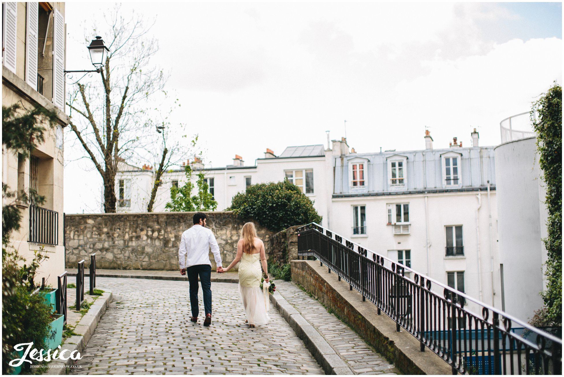 destination wedding photographer - couple hold hands walking down street in mont marte