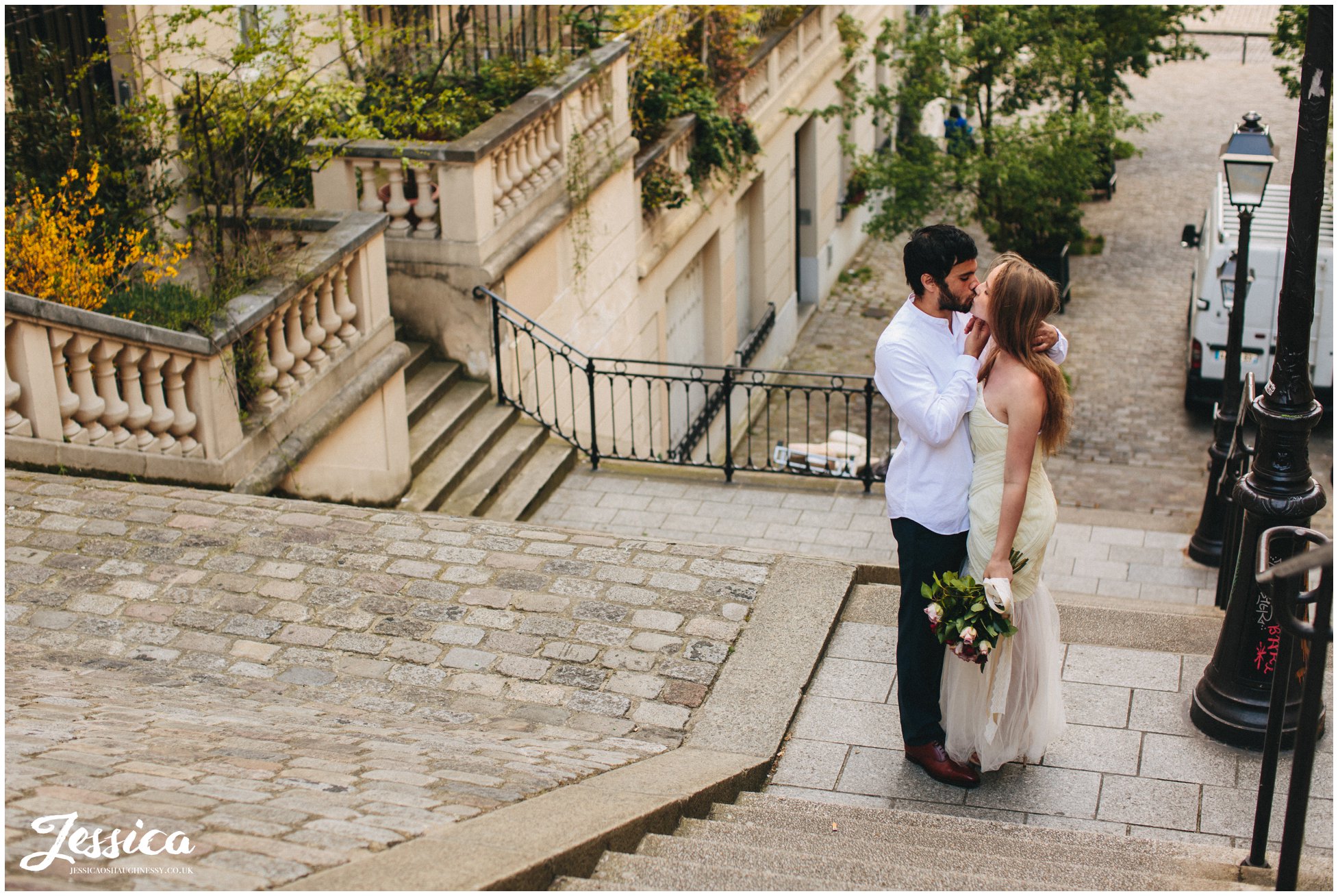 couple kissing on steps on their wedding day in paris