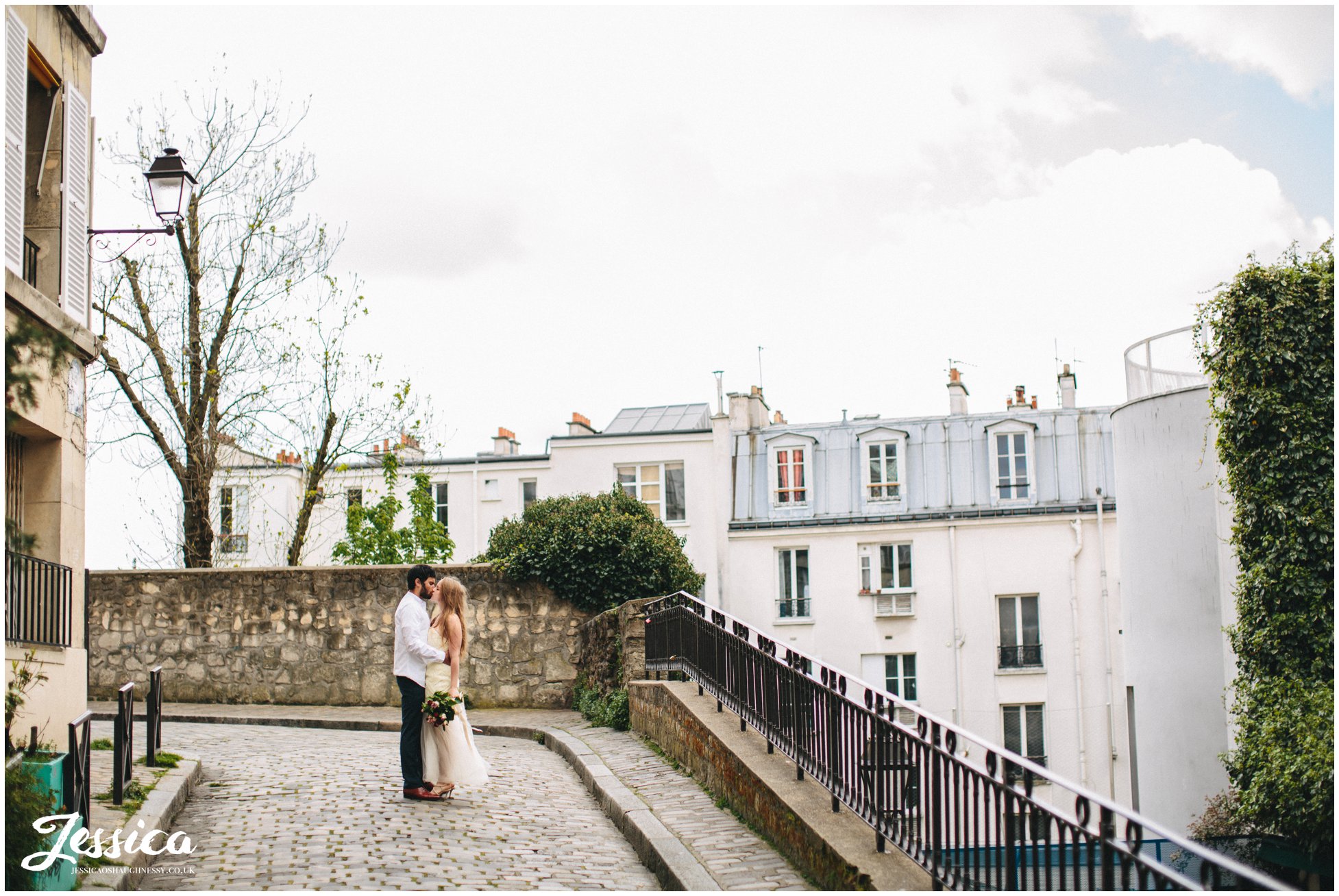 newly weds kiss on parisian street - france wedding photographer