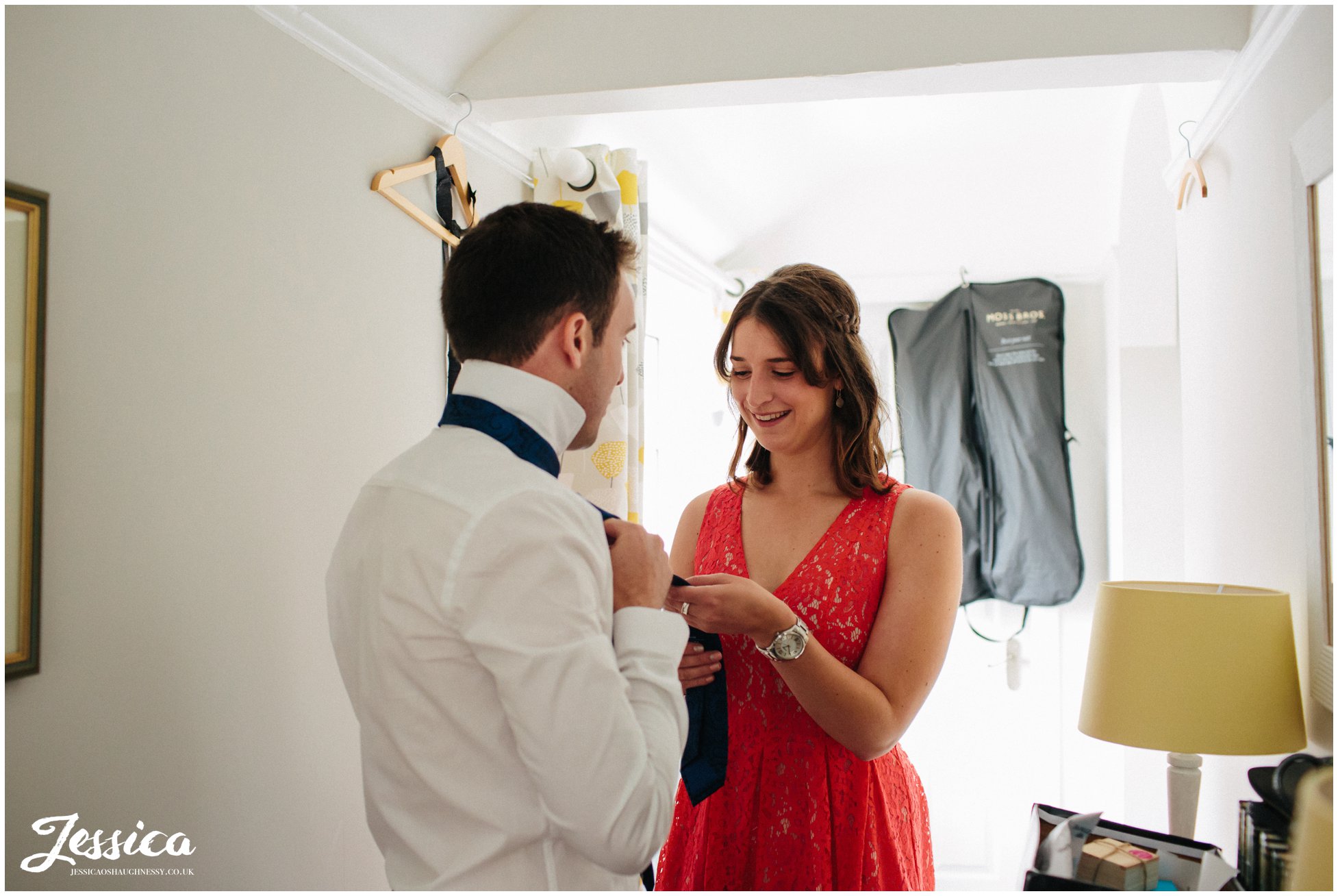 bride's brother having his tie fastened in preparation for the wedding at farndon church