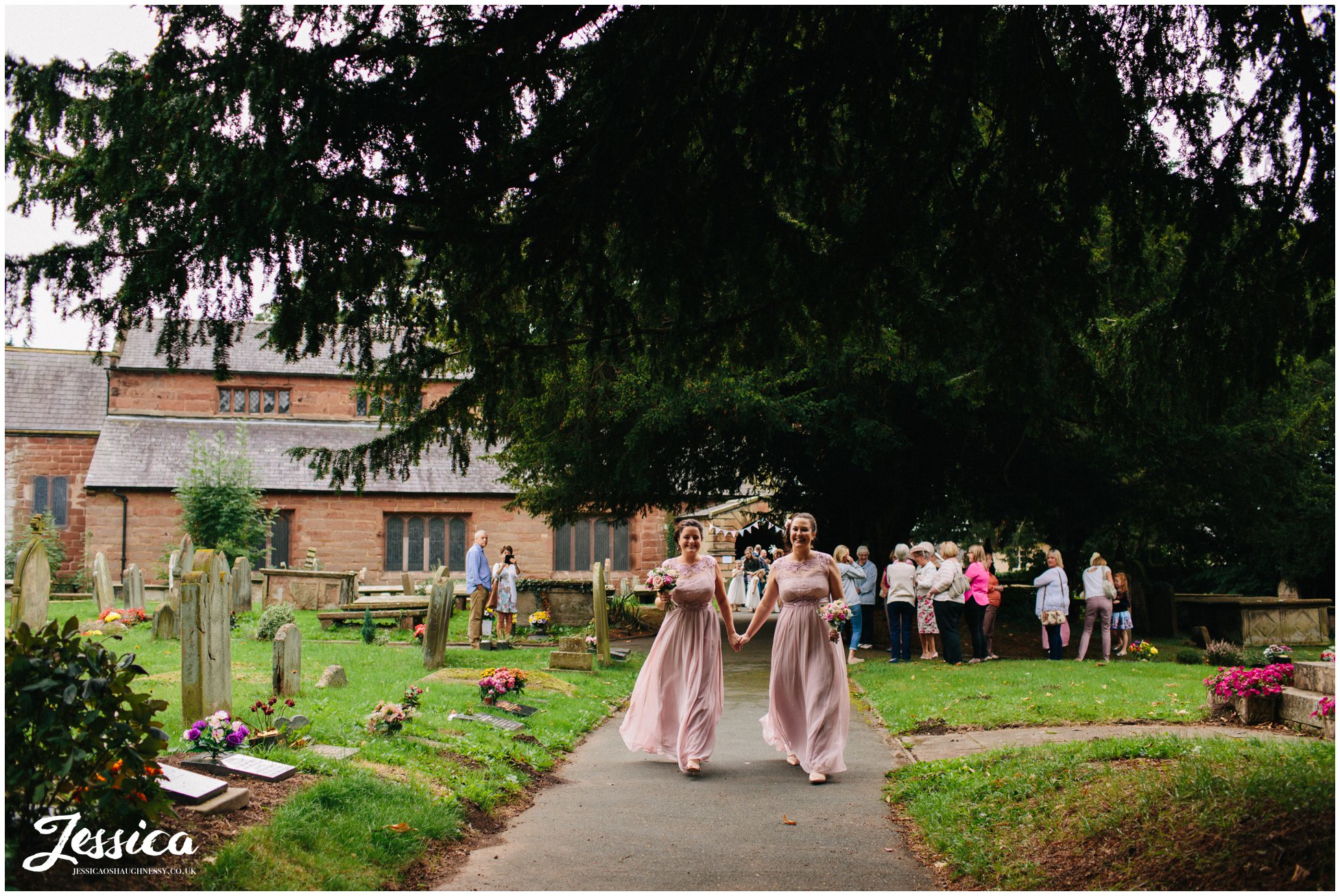 bridesmaids walk to meet the bride as she arrives at st chad's church in farndon