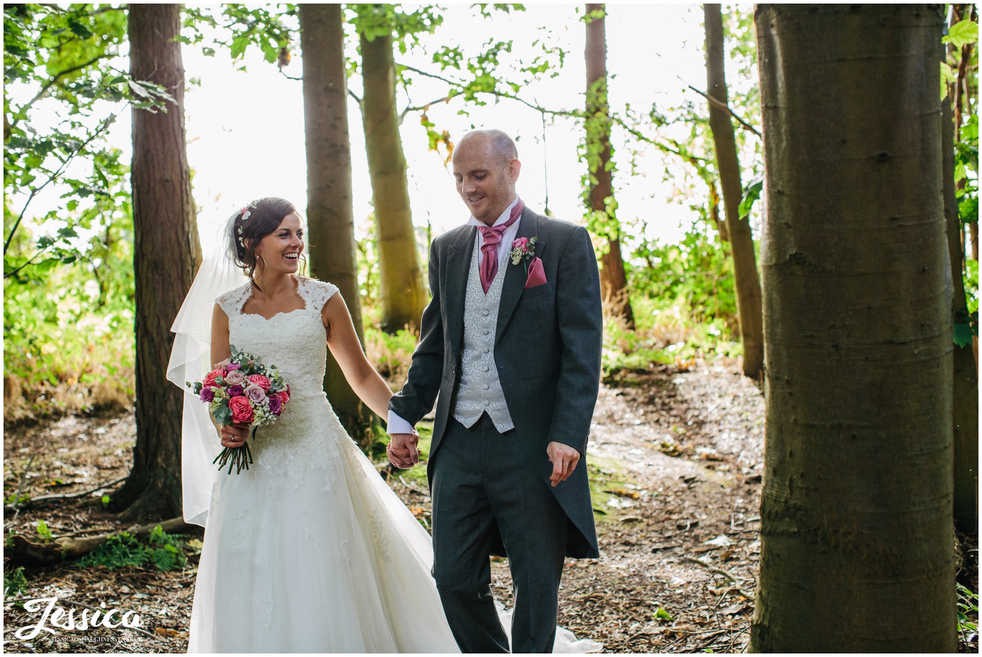 Newly wed's walk through the forest on their wedding day in cheshire