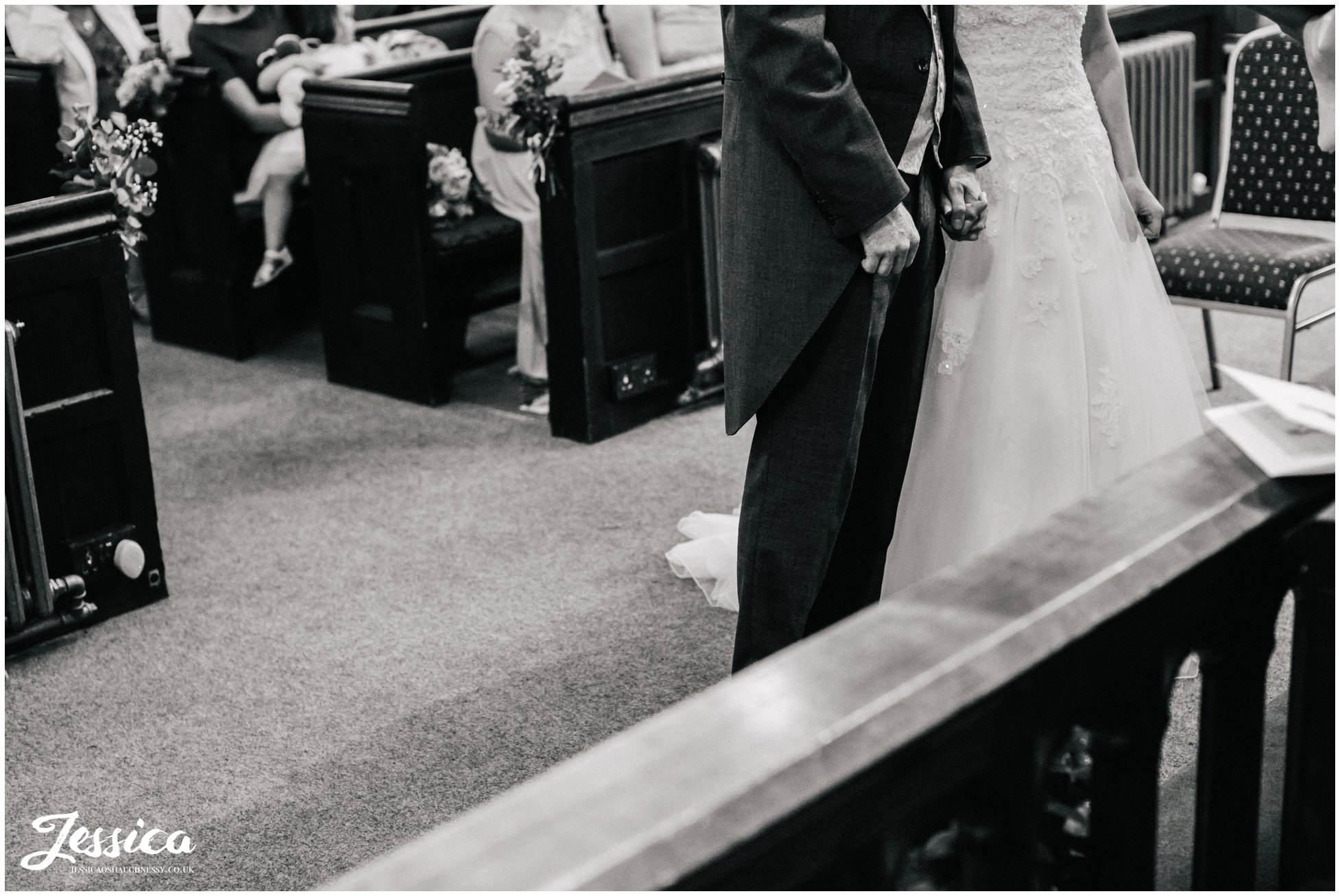 bride & groom hold hands during their ceremony at st chad's church in farndon, chester