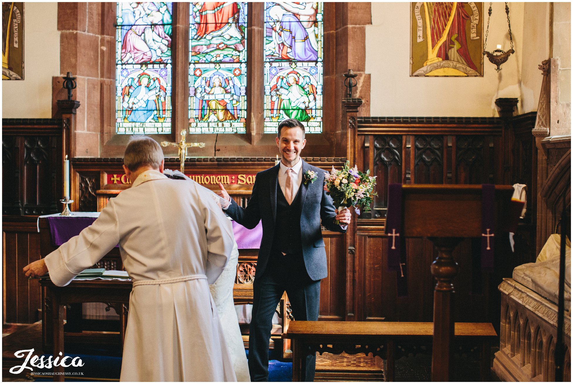 groom holds his brides bouquet whist laughing - north wales wedding