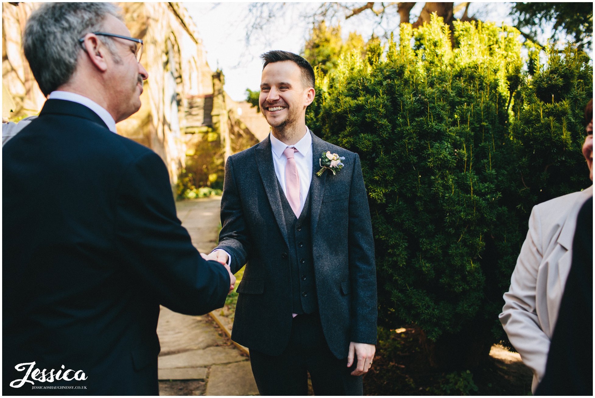 guest shakes the grooms hand after he gets married in hawarden