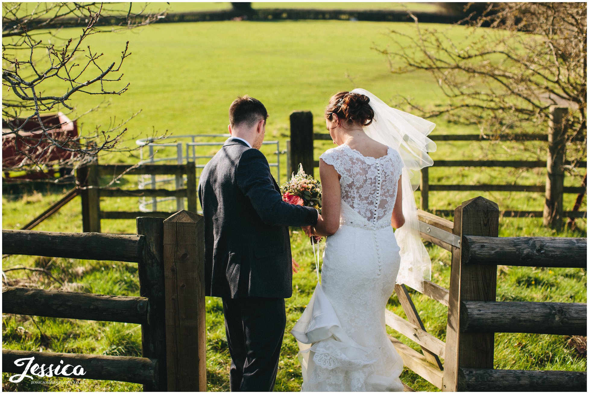 groom helps his bride through wooden gate on their wedding day - north wales wedding photographer
