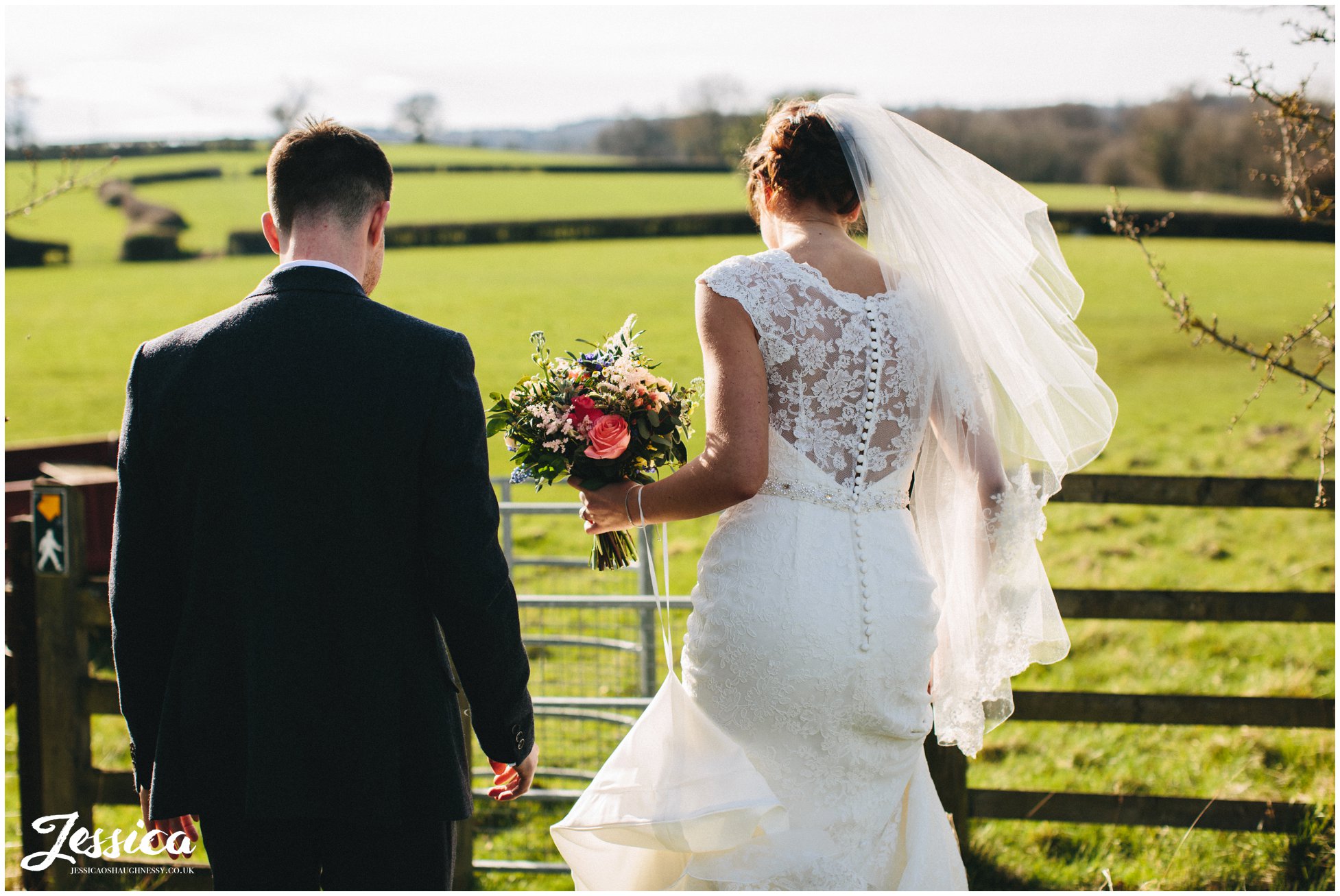 newly wed's walk in the sunlight at a rustic wedding at tower hill barns