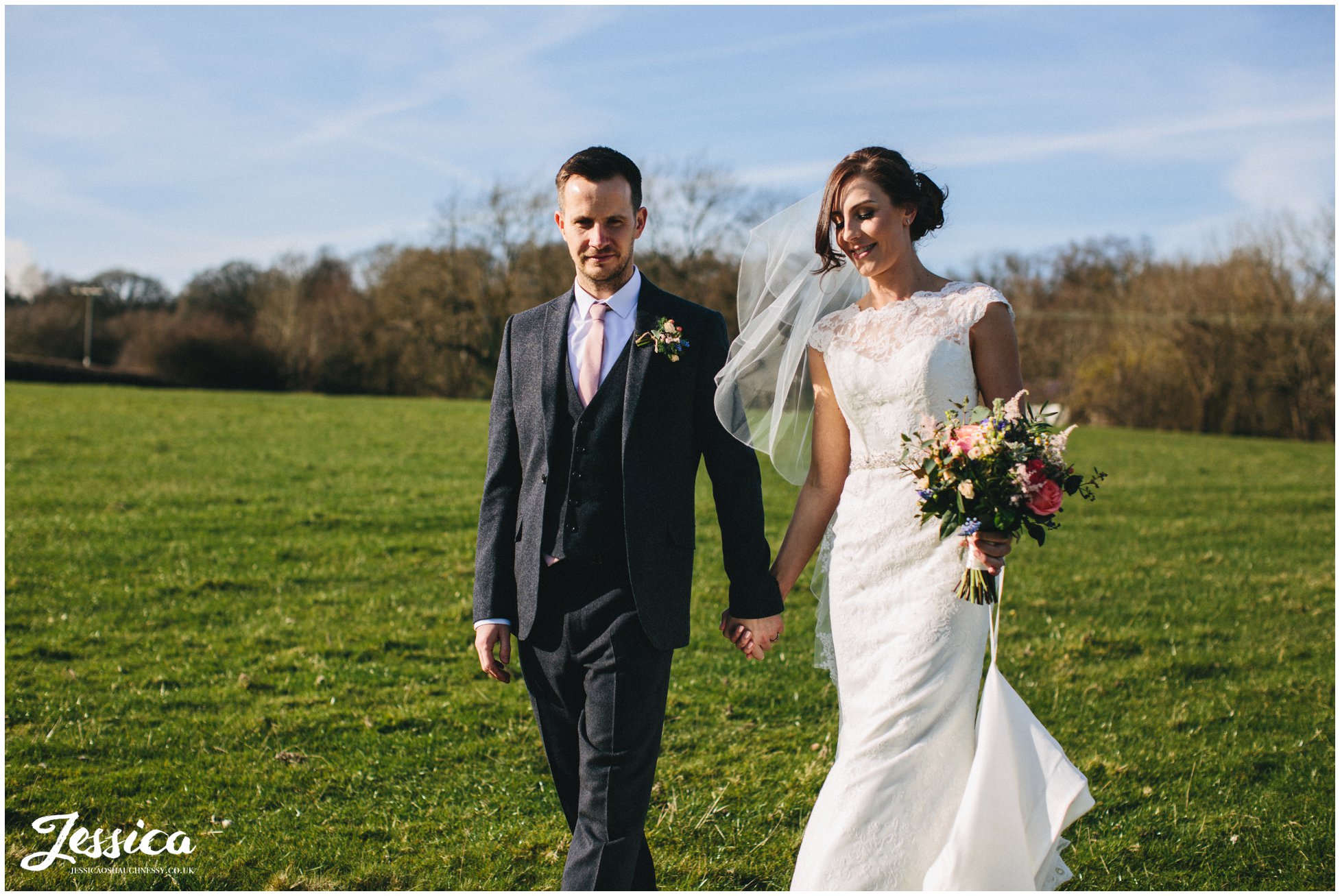 husband & wife walk in the sun at their wedding in north wales