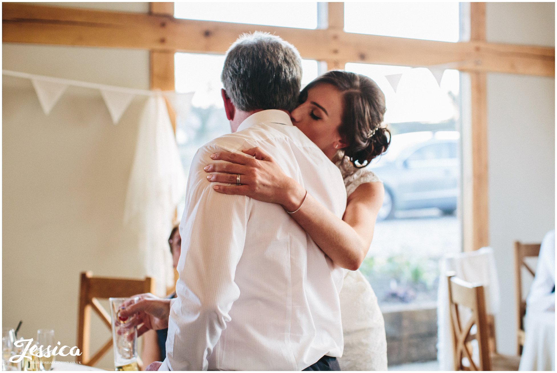 bride hugs her father after his speech on her wedding day in north wales