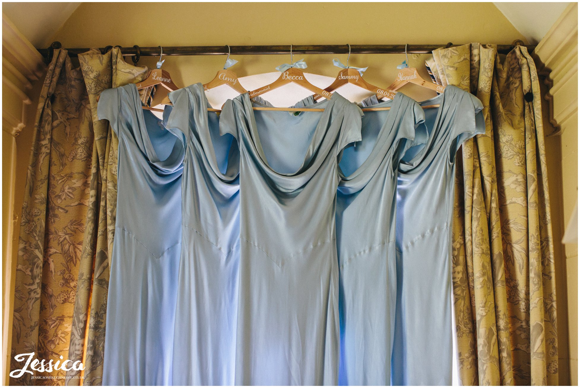 light blue bridesmaid dresses hanging in the stone lodge, Combermere Abbey