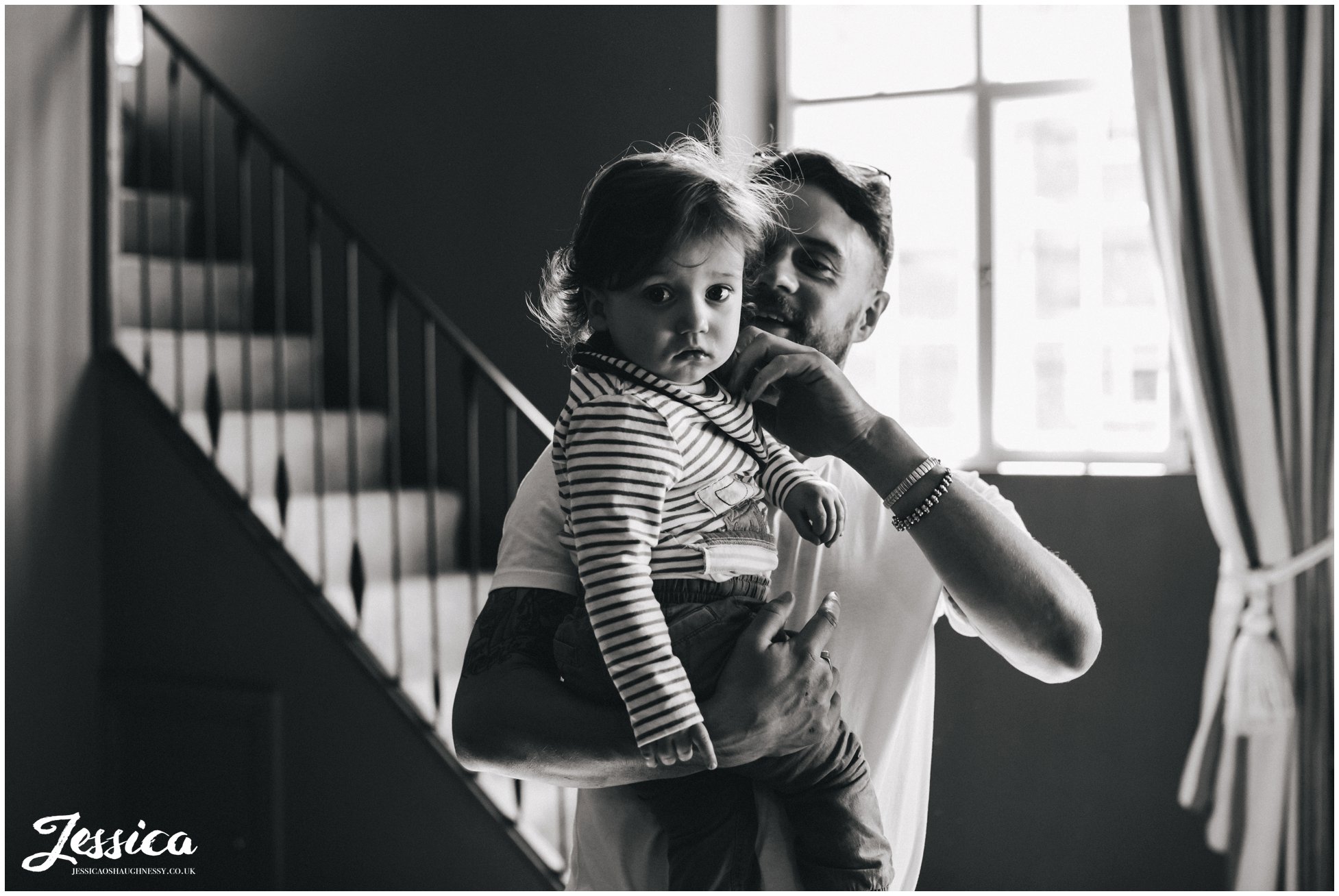 groom holds his son on the morning of his wedding