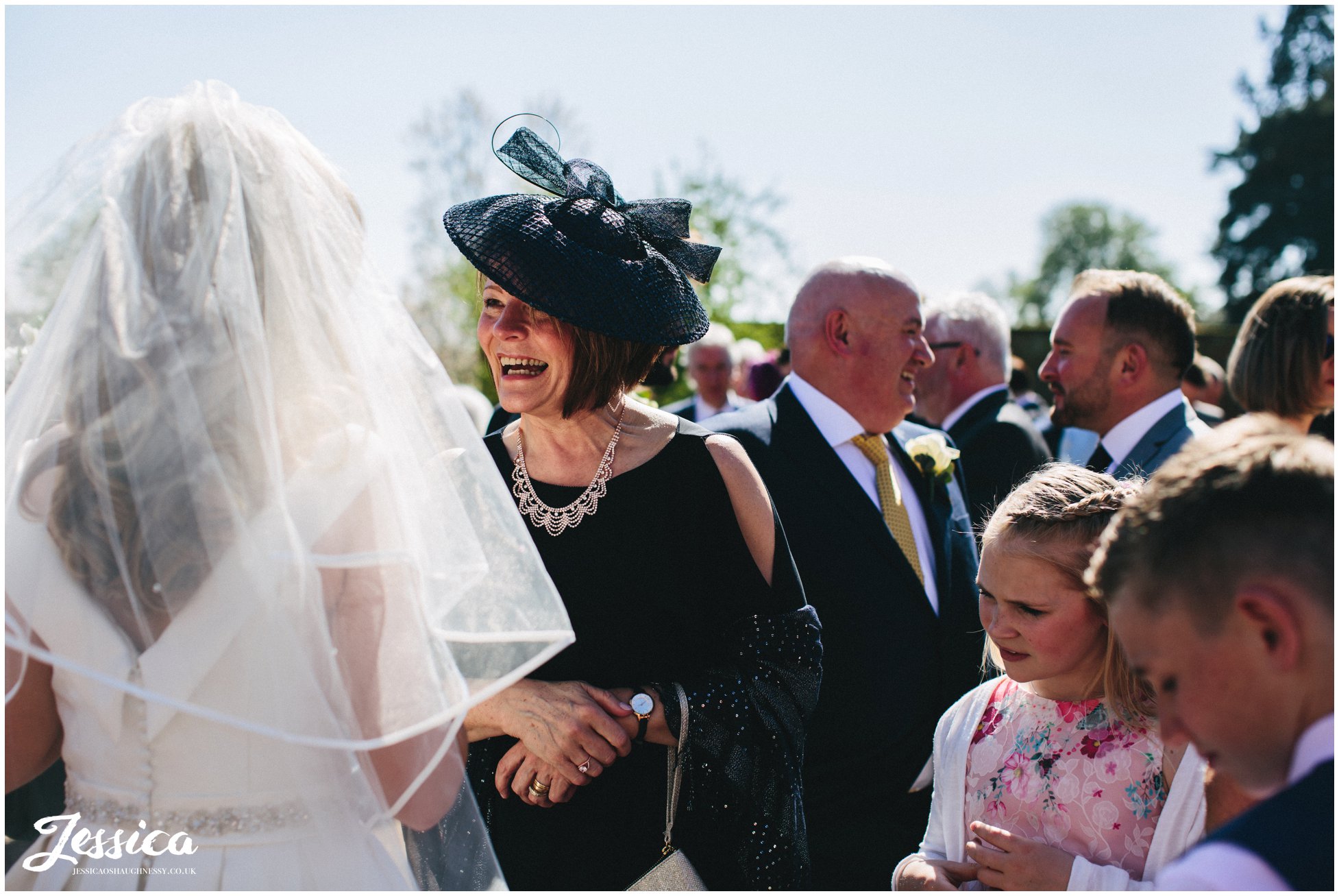 mother of the groom laughs with bride on her wedding day