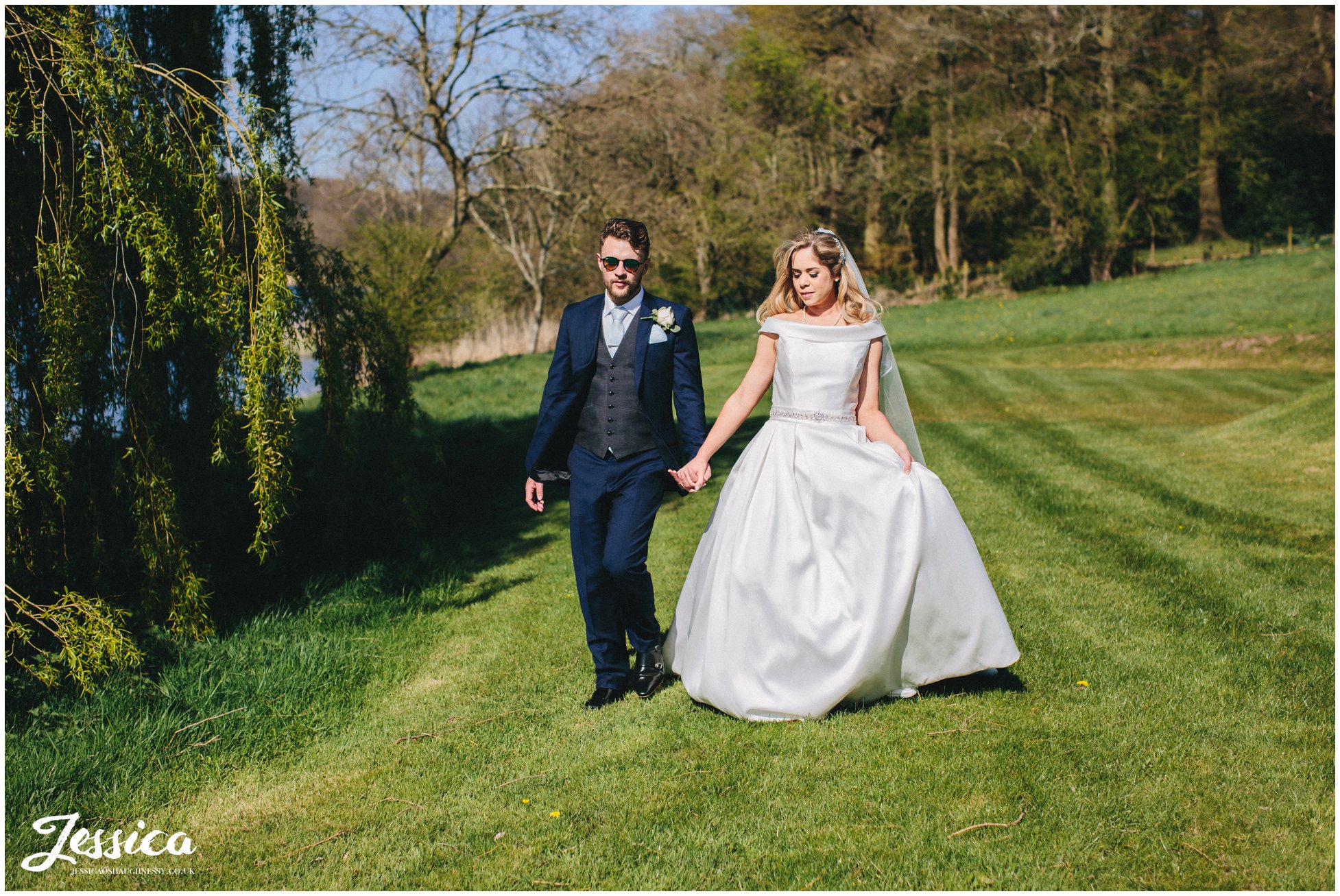 couple walking by a lakeside willow tree, Combermere Abbey