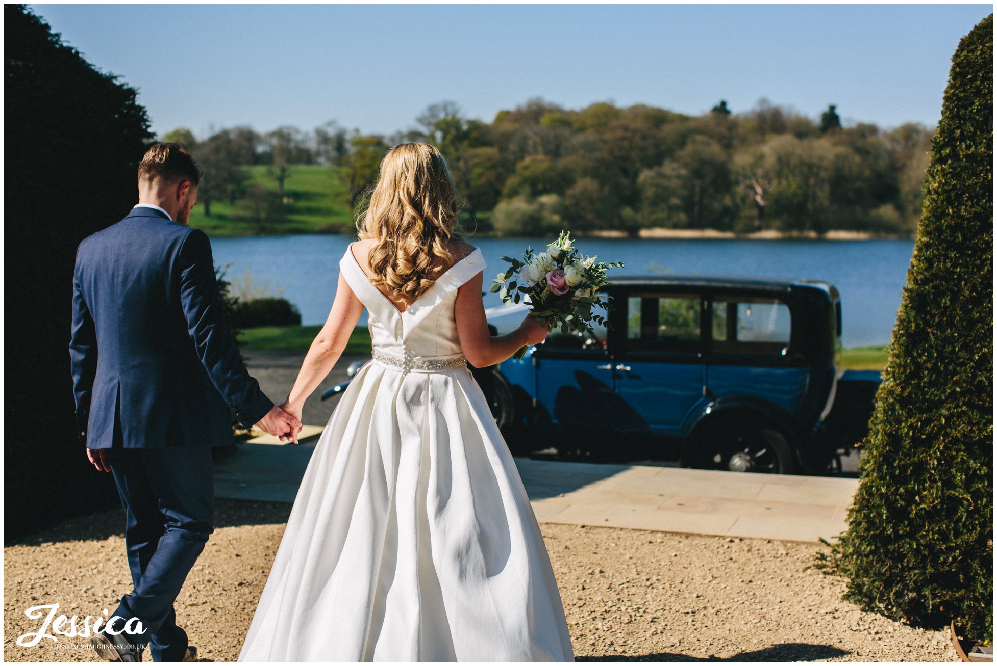 couple walk towards their wedding car at Combermere Abbey in whitchurch