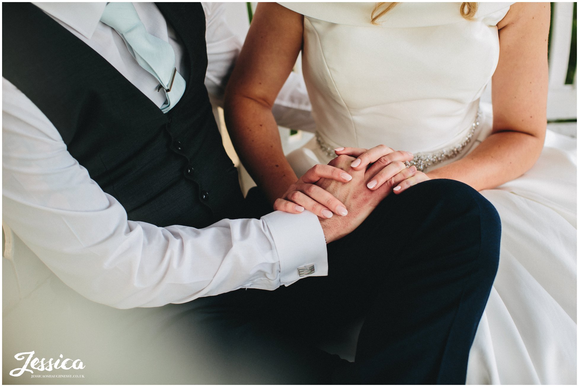 close up of bride & groom holding hands