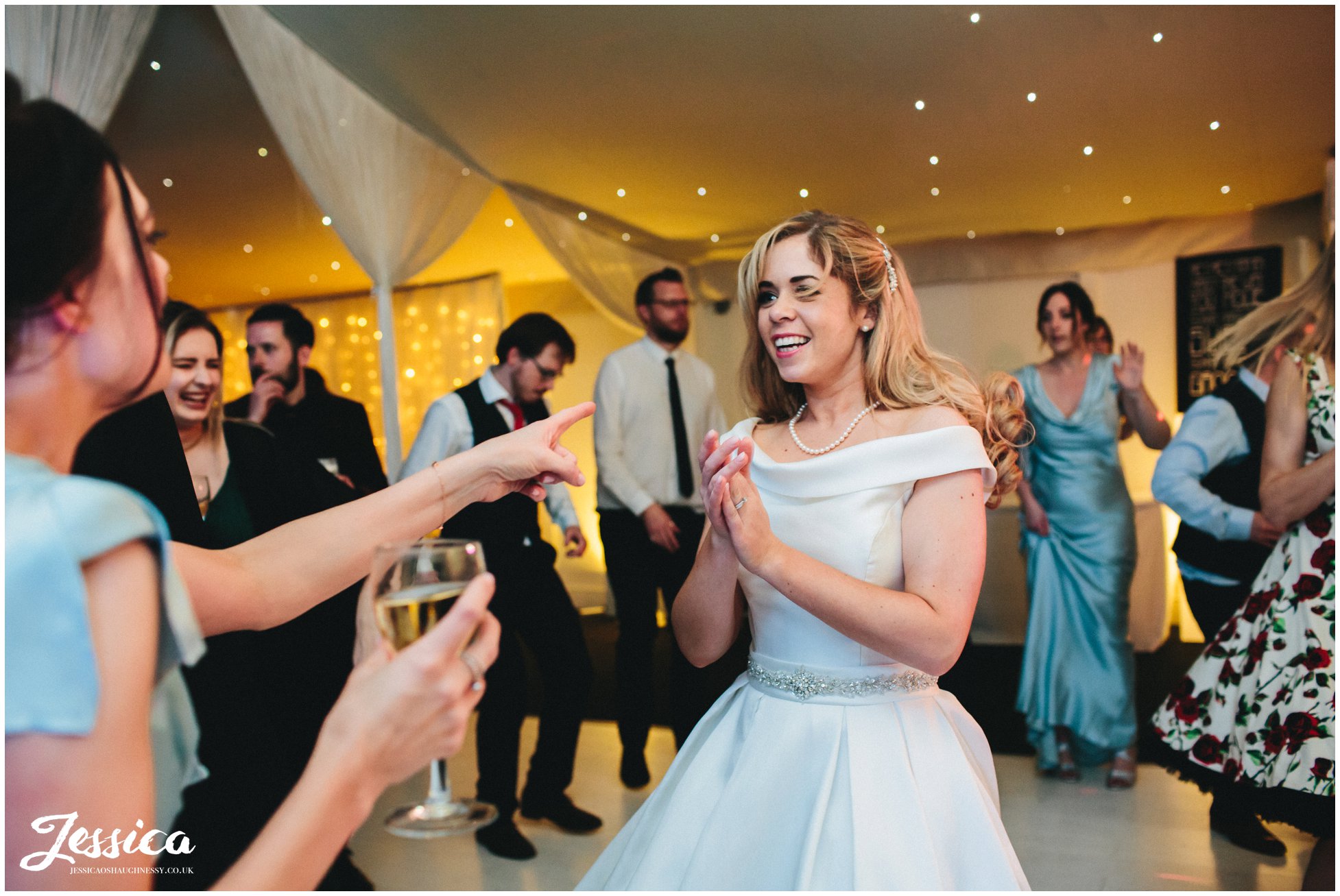 bride dances with bridesmaid during her wedding reception in the pavilion