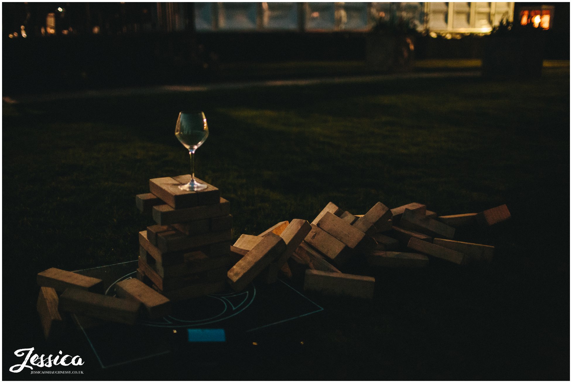wine glass balances on jenga after a wedding at Combermere Abbey