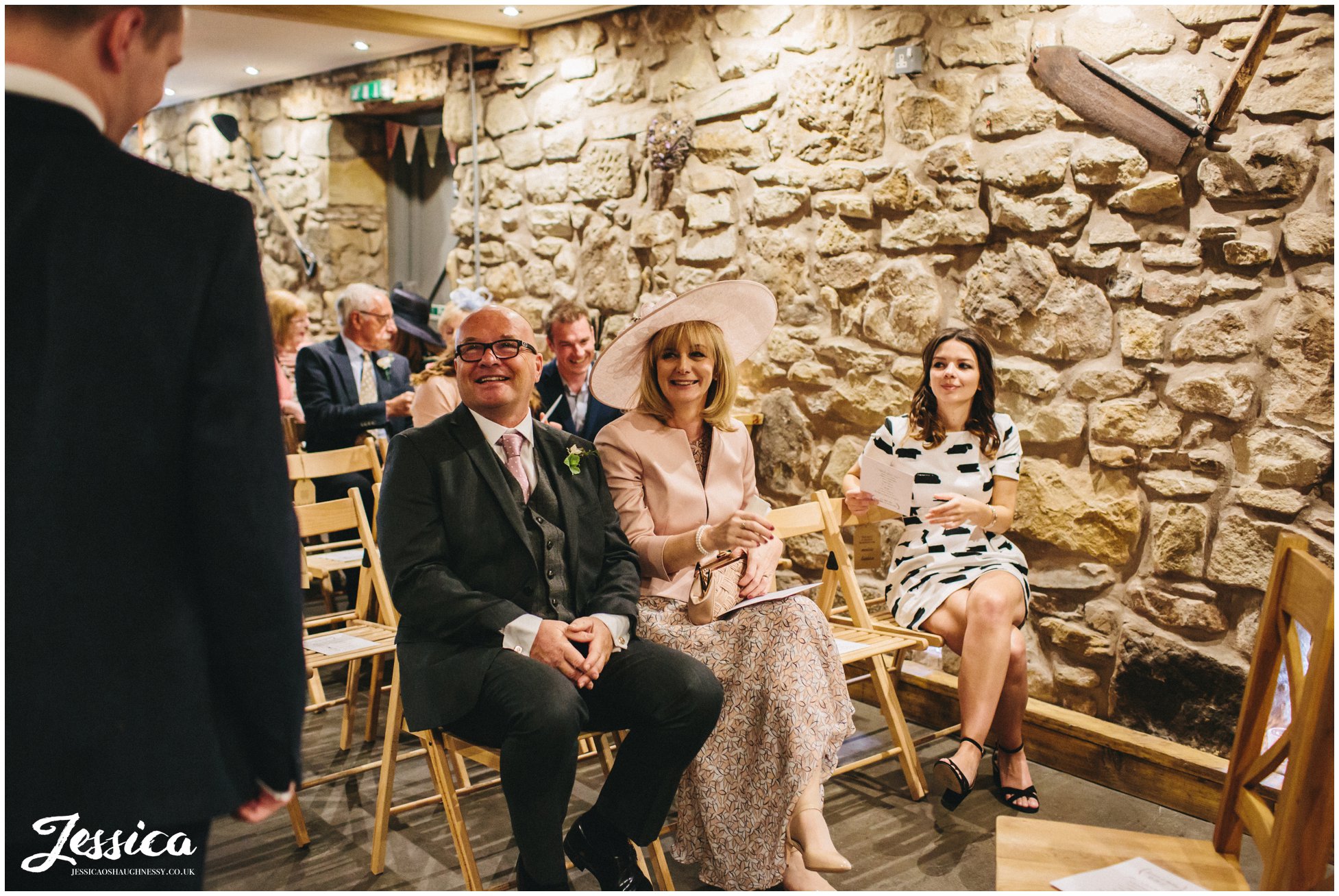 parents of the bride sit and wait for the ceremony in the barn