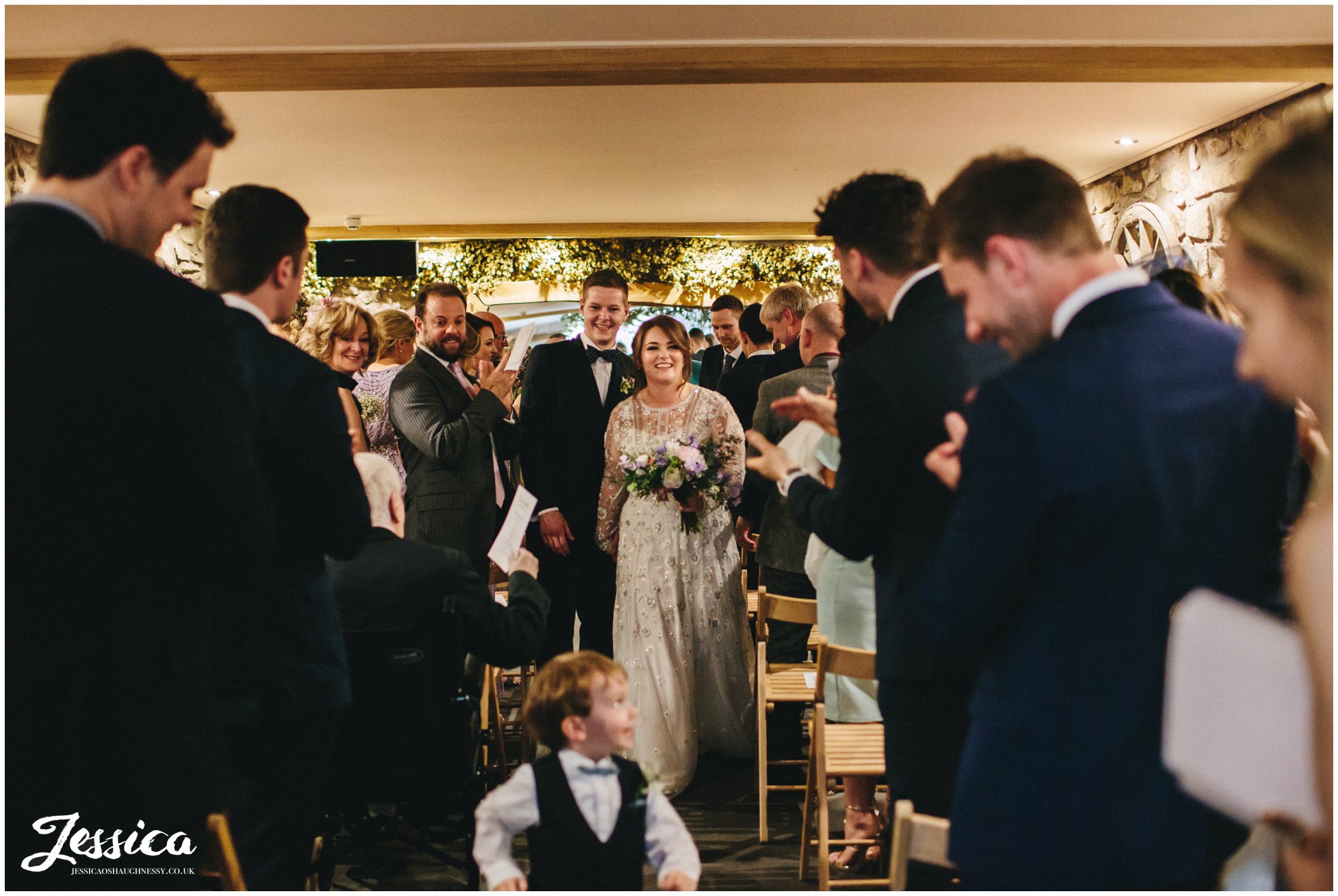 newly wed's walking down the aisle together and mr & mrs