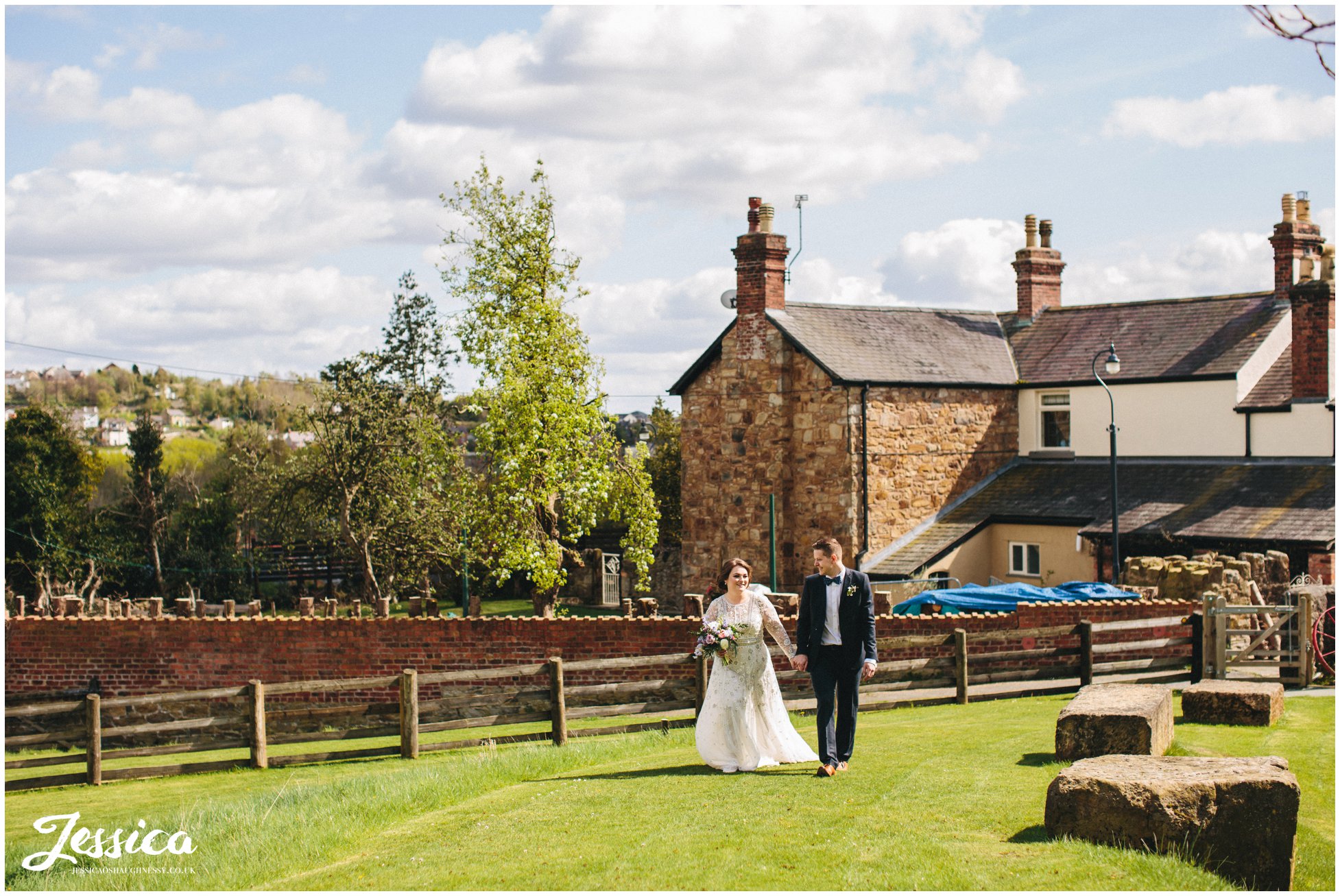 bride & groom walk towards the bridge holding hands