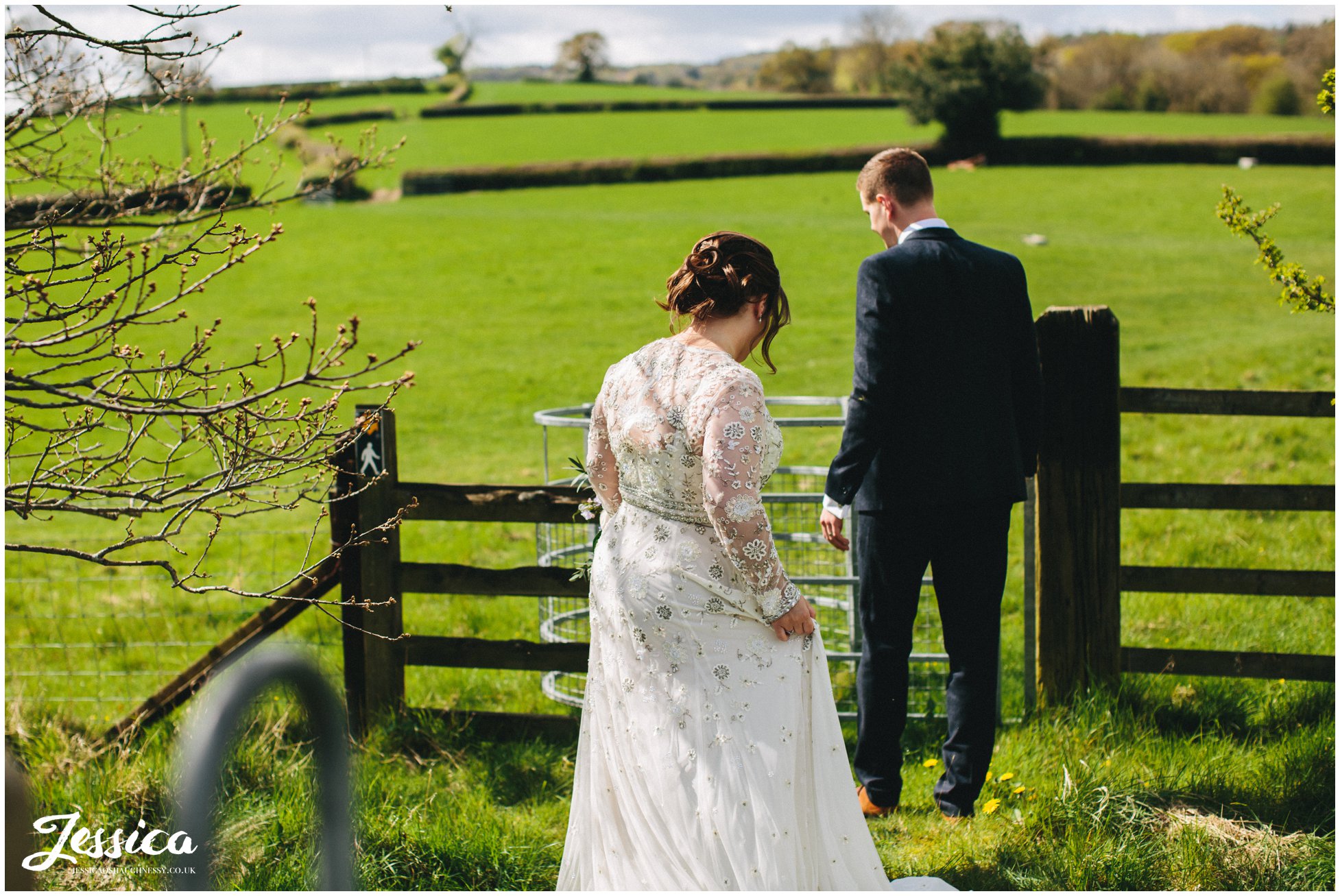 newly wed's walk through gates into field