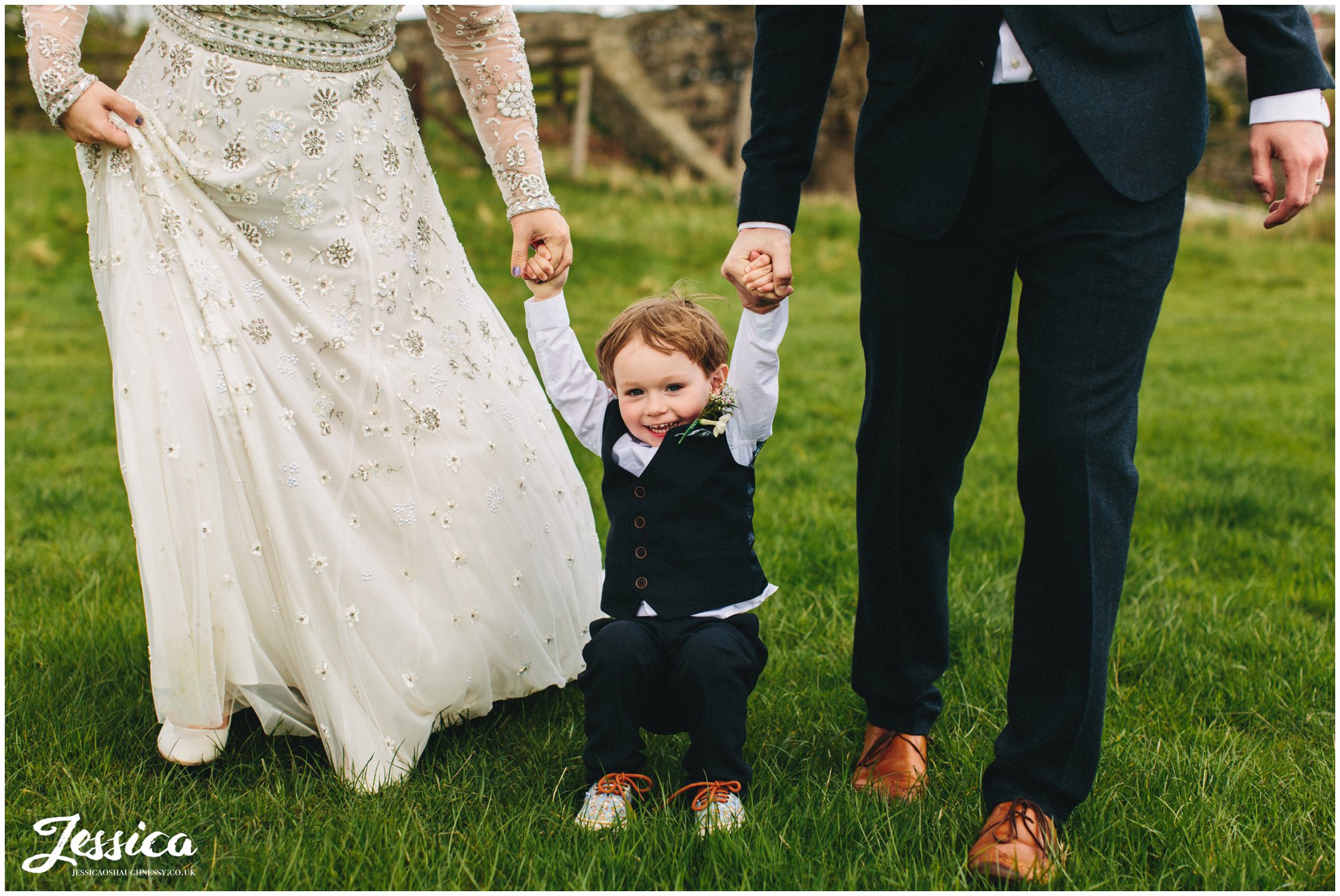 child holds parents hands at a wedding in trevor, wrexham