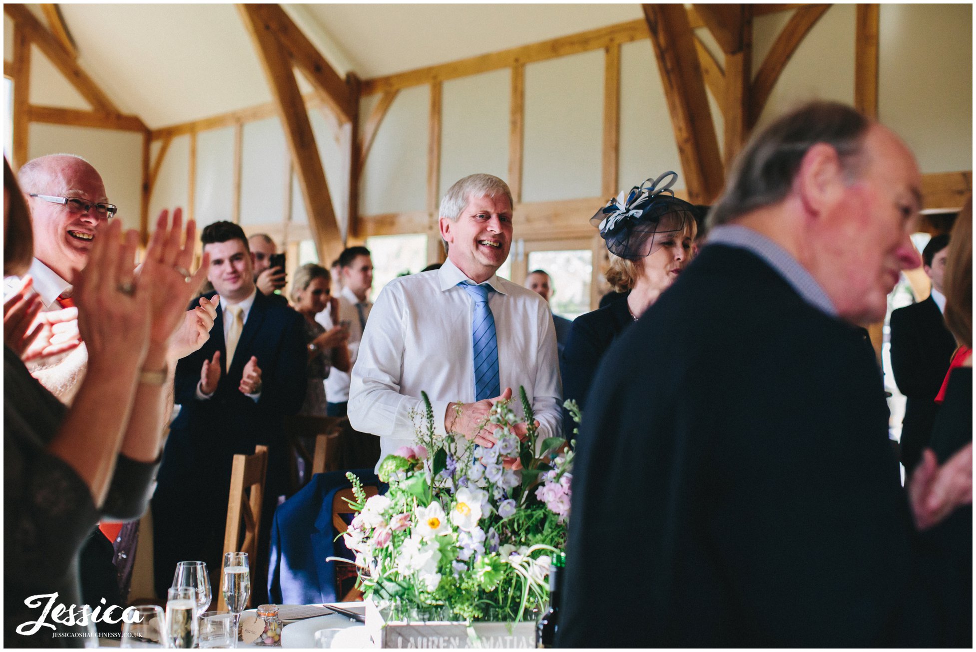 guests clapping as bride & groom enter the room