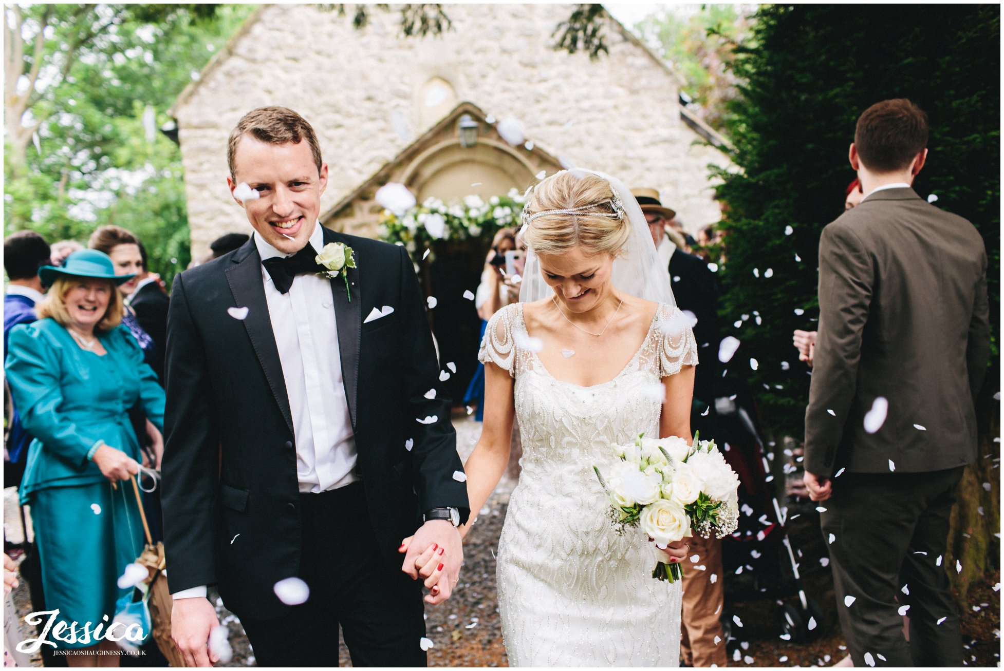 newly wed's walk through confetti line after their ceremony in Trevor, North Wales